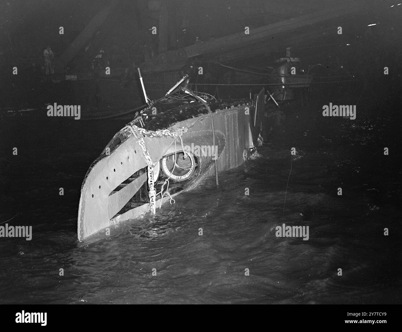 KLAFFENDES LOCH IN ' TRUCULENT ' ALS U-BOOT ERHÖHT GESEHEN der Rumpf des U-Bootes Truculent erschien heute Abend über der Oberfläche der Themse, nachdem sie von den Hebeoperationen aus dem Schlammbett angehoben worden war, in das sie am 12. Januar sank, mit dem Verlust von 64 Menschenleben, nachdem ein U-Boot mit dem schwedischen Tanker Divina kollidiert wurde, in dem sich ein U-Boot eingelocht hatte. Vier doppelte neun-Zoll-Stahlhawser waren um das U-Boot gelegt worden, als es 10 Meilen vor sheerness unter 54 Fuß Wasser lag, und zwei der leistungsstärksten Hebeschiffe der Welt, die Energie und die Ausdauer, wurden eingesetzt Stockfoto