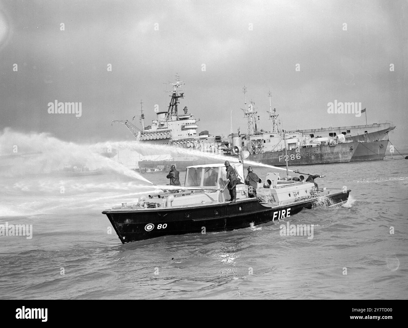 TESTS DER STRÖME Feuerlöschvorrichtungen, die die R.A.F.-Tender ersetzen sollen, die heute im Einsatz sind, wurden heute im Hafen von Portsmouth demonstriert. Die Modellnummer 81, der größte der ausgestellten Typen, ist 60 Meter lang. Es besteht aus einer Aluminiumlegierung, obwohl die kleinere Ladefläche, Nummer 80, 55 Fuß lang ist und aus Weichstahl besteht. Zu den Hauptmerkmalen der neuen Modelle gehören eine bessere Manövrierfähigkeit, eine höhere Feuerwehrkapazität und niedrigere Decks, die es dem Schiff ermöglichen, unter Wasserflugzeugflügeln zu fahren. Beide Schiffe fahren mit 2 1/2 KN und sind mit einem Loudhailer ausgestattet Stockfoto