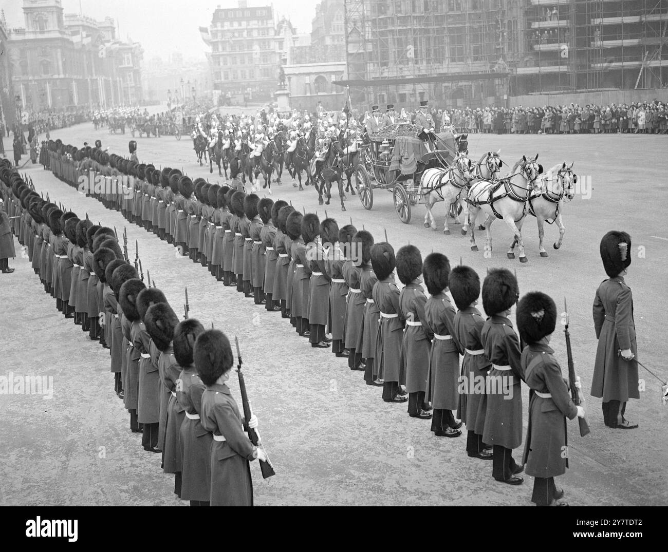 KÖNIG UND KÖNIGIN KOMMEN IM PARLAMENT AN. KÖNIG und Königin fuhren heute mit einer souveränen Eskorte der Haushaltskavallerie vom Buckingham Palace zum Haus der Lords, um das Parlament zu eröffnen. Nach der Rede des Königs, in der die Pläne der Regierung für die kommende Sitzung angekündigt wurden, kehrten die majesties in den Palast zurück. Die Route der heutigen Fahrt war schwul mit Dekorationen, die speziell für den morgigen Staatsbesuch des französischen Präsidenten in London entworfen wurden. DAS BILD ZEIGT:- die Szene, als der König und die Königin in der irischen Staatskutsche reiteten - in Begleitung eines Sover am Parlamentsgebäude ankamen Stockfoto