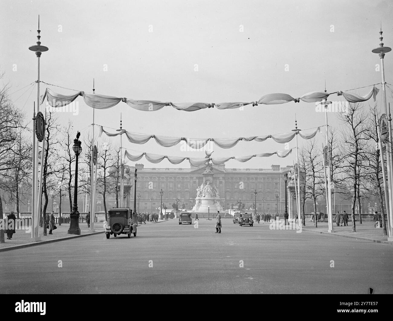 DIE MALL ALS " TUNNEL " VON GAIETY FÜR DEN FRANZÖSISCHEN PRÄSIDENTEN BESUCHEN SIE die Mall - l Blick in Richtung Buckingham Palace (Hintergrund), abgebildet in seiner schwulen Seite-zu-Seite-Dekoration für den nächsten Wochen Staatsbesuch der französischen Präsidenten, M. Vincent Auriol und Madame Auriol. Die Normen , die die Dekorationen stützen , tragen abwechselnd britische und französische Abzeichen . 4. März 1950 Stockfoto