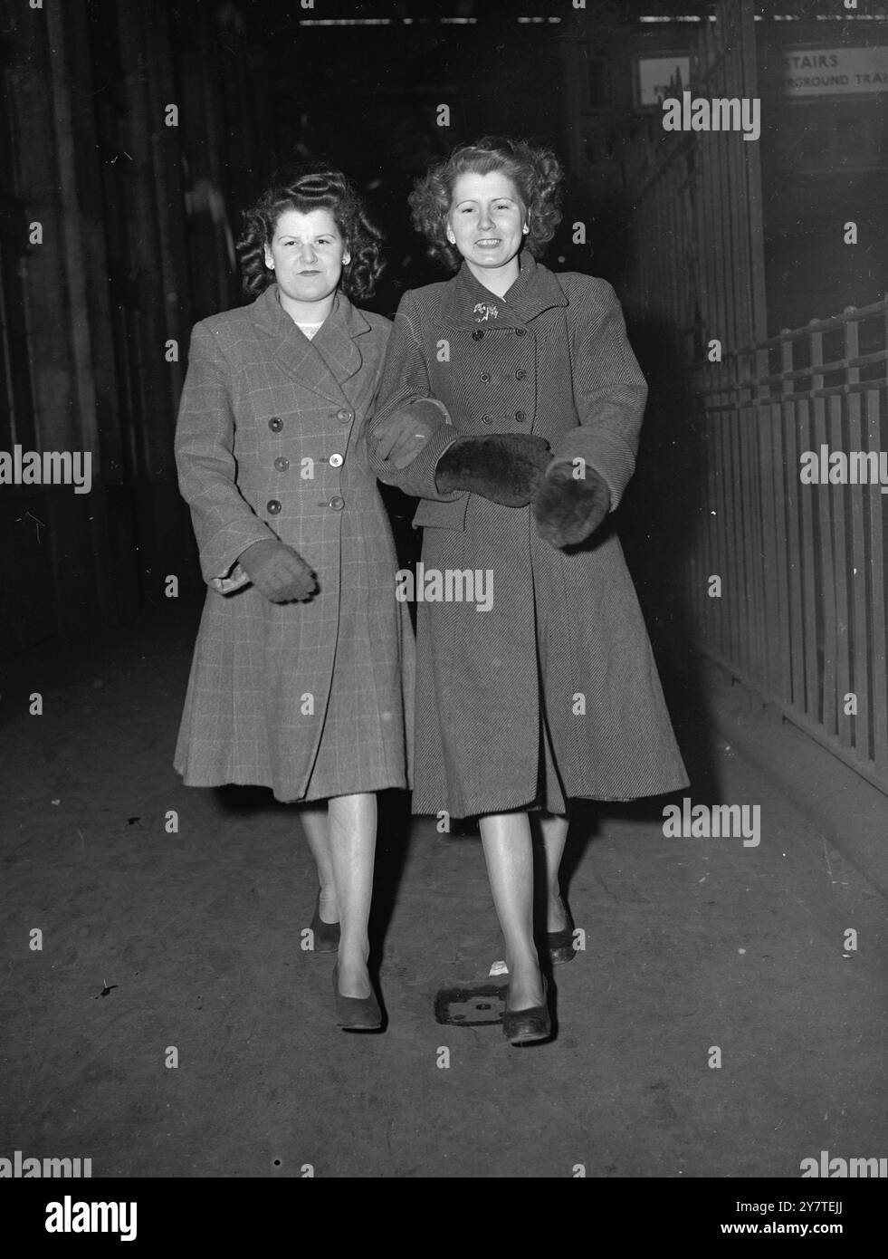 Die TRADITION SETZT DIE Armeetradition der Familie Hobbs FORT, die heute an Stärke gewonnen hat, als Sylvia Helen Hobbs (links), 18, und ihre Schwester Sybil Rosalind Hobbs, 17 1/2, Waterloo Station, London verlassen, um ihre Ausbildung in der W.R.A.C.Trainingseinheit in Guildford, Surrey, aufzunehmen. Der Vater der Mädchen ist ein ehemaliger Mann der Armee, da drei ihrer Brüder im Dienst stehen. Drei ihrer Schwestern dienten in dieser A.T.S., und zwei jüngere Brüder warten darauf, die Militärschule des Duke of York zu betreten. Es gibt 16 Mitglieder in der Familie Hobbs. 17. Februar 1950 Stockfoto