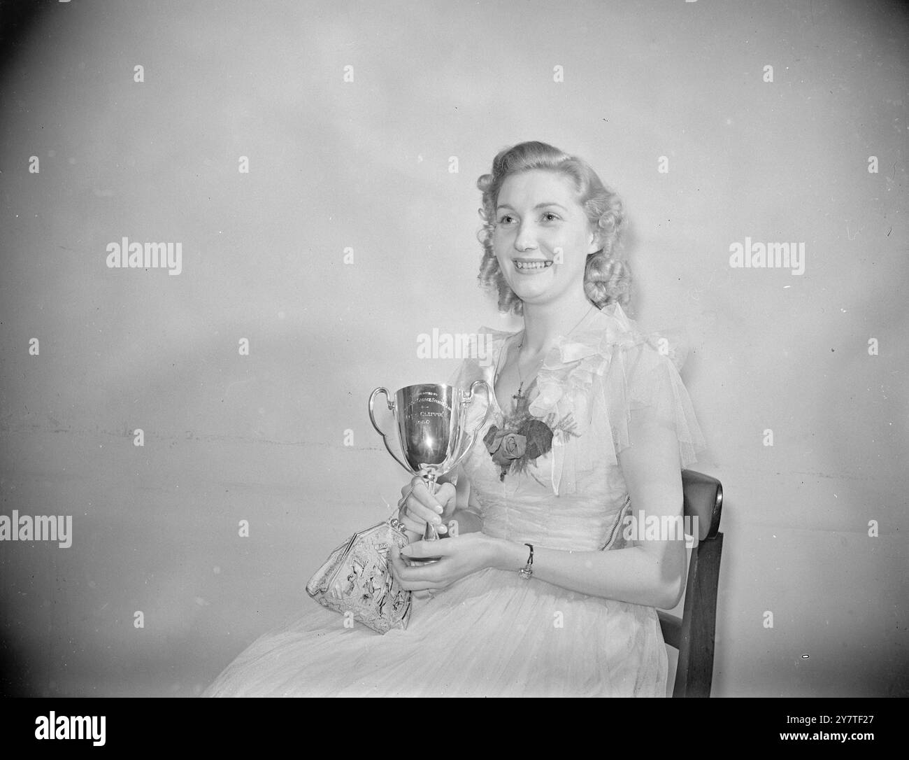 Der SIEG von CLIPPIE mit dem Siegpokal und dem Lächeln, das ihre Passagiere verzaubert, ist Miss Grace Webber, eine Londoner Transportführerin der Middle Road Garage in North Kensington, London, die hier abgebildet wurde, nachdem sie unter über 40 Teilnehmern des Clippie Ball in Seymour Hall, London, zur Miss Clippie of 1950 gewählt wurde. 15. Februar 1950 Stockfoto