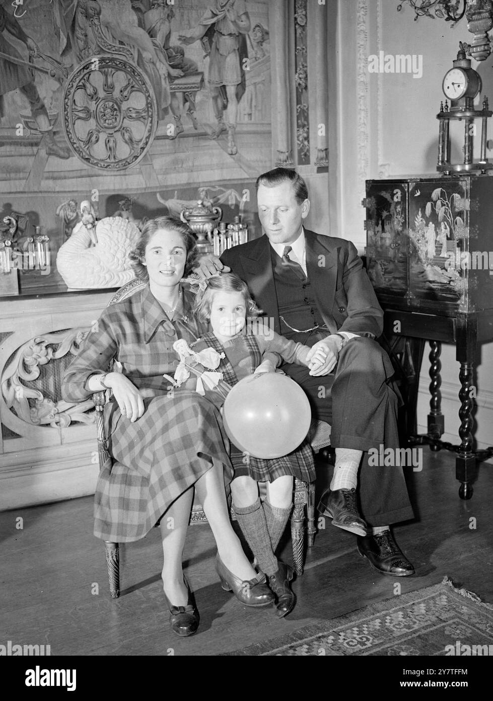12. Februar 1950 die Niederlage Großbritanniens wird Südafrikas Gewinn sein, als am 17. Februar diese glückliche Familie, im chesham Place 37 in London, nach Johannesburg aufbricht. Das sind Mr. Und Mrs. Michael Menzies und ihre 6-jährige Tochter Virginia. (Mrs. Menzies) ist Kay Stammers, Tennisspielerin in Wimbledon und Kapitän des British Wightman Cup. Mr. Menzies wird Finanzdirektor in Johannesburg und die Familie wird in einem Haus - komplett mit Tennisplatz - wohnen, etwa 19 Meilen vom Zentrum der Stadt entfernt. Bevor sie gehen, hat Frau Menzies etwas eingebracht Stockfoto