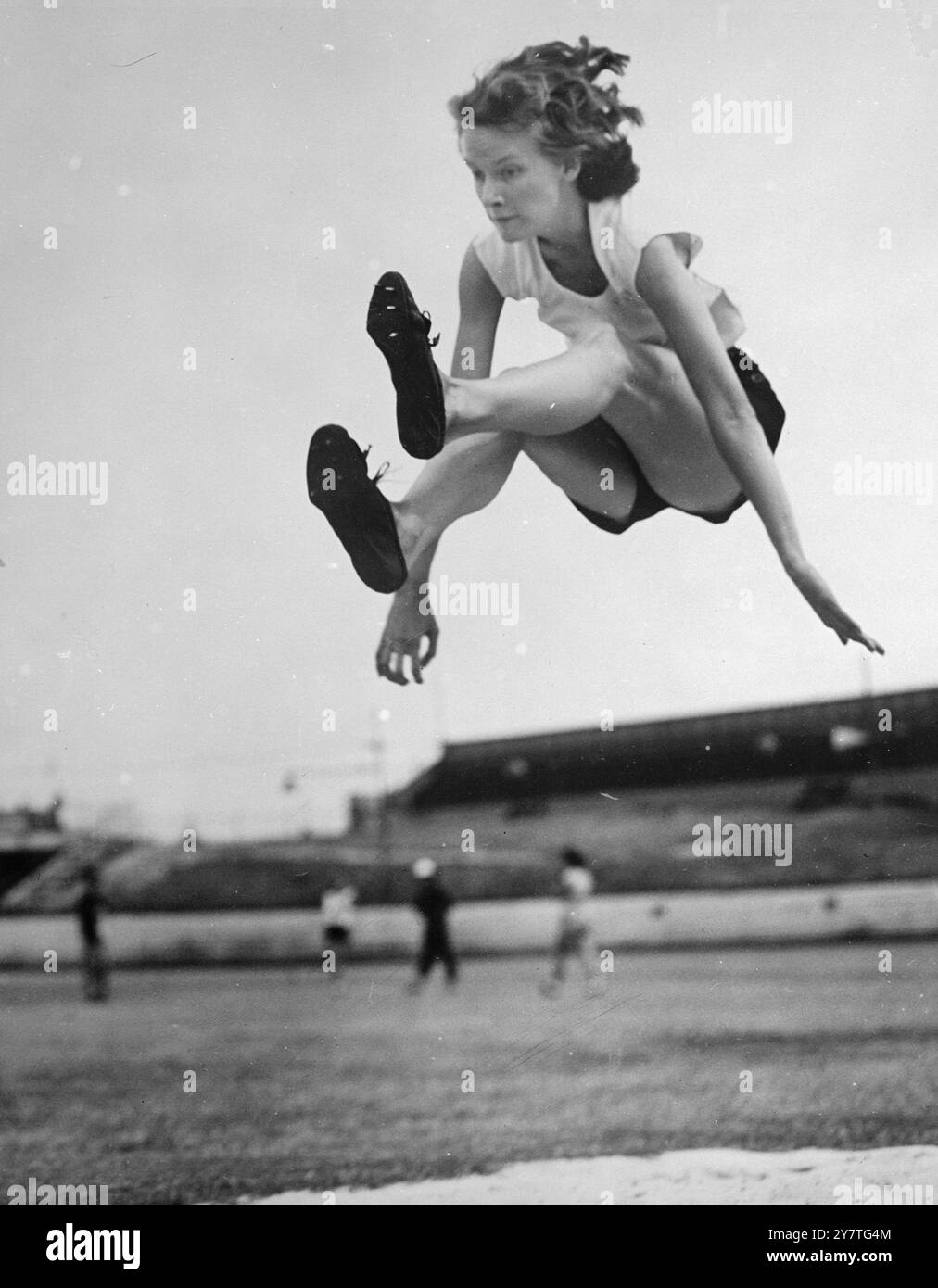 SIE FLIEGT DURCH DIE LUFT Judy Canty, 18, aus New South Wales, eine der neun führenden australischen Athleten, die ausgewählt wurde, das Land bei den Empire-Spielen in Auckland, Neuseeland, im Februar zu repräsentieren. Sie hält den australischen Sprungtitel mit einer Entfernung von 18 Fuß 6 1/2 Zoll. 26. Januar 1950 Stockfoto