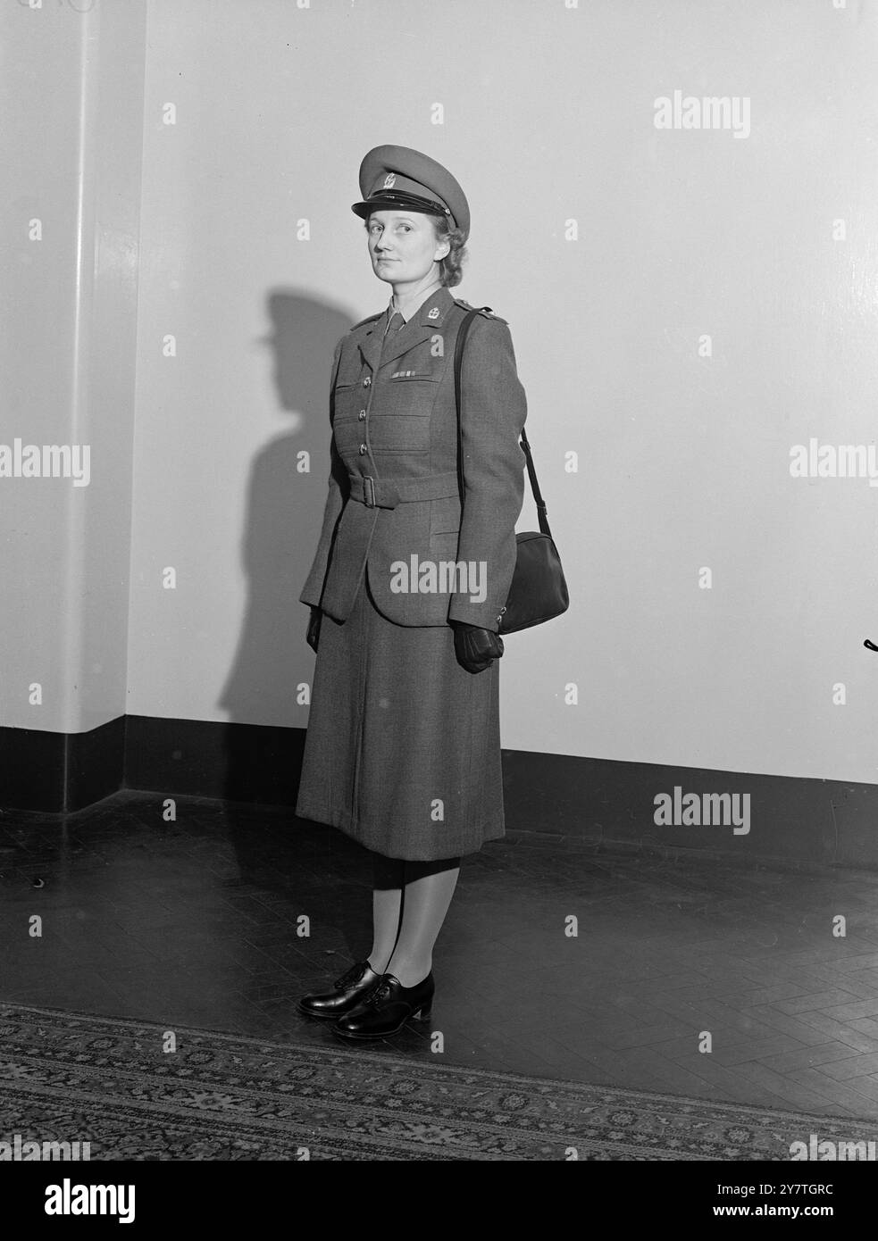 NEUE UNIFORMEN FÜR ARMEESCHWESTERN 4. November 1949 neue Uniformen für das Royal Army Corps der Frauen und das Royal Army Nursing Corps der Königin Alexandra wurden heute am Whitehall Place in London gezeigt. Die Uniformen wurden von Norman Hartnell, der Schneiderin der Königin, entworfen. Das Bild zeigt: Das neue nicht-zeremonielle Kleid für Subalterns auf dem Q.A.R.A.N.C. das traditionelle Grau wurde beibehalten, obwohl das Grau dunkler ist. Die Kappe ist aus grauem Pelzfilz mit schwarzem, japanischem Schirm. Jacke und Rock sind aus grauem Barathea, mit Gürtel aus demselben Material. Stockfoto