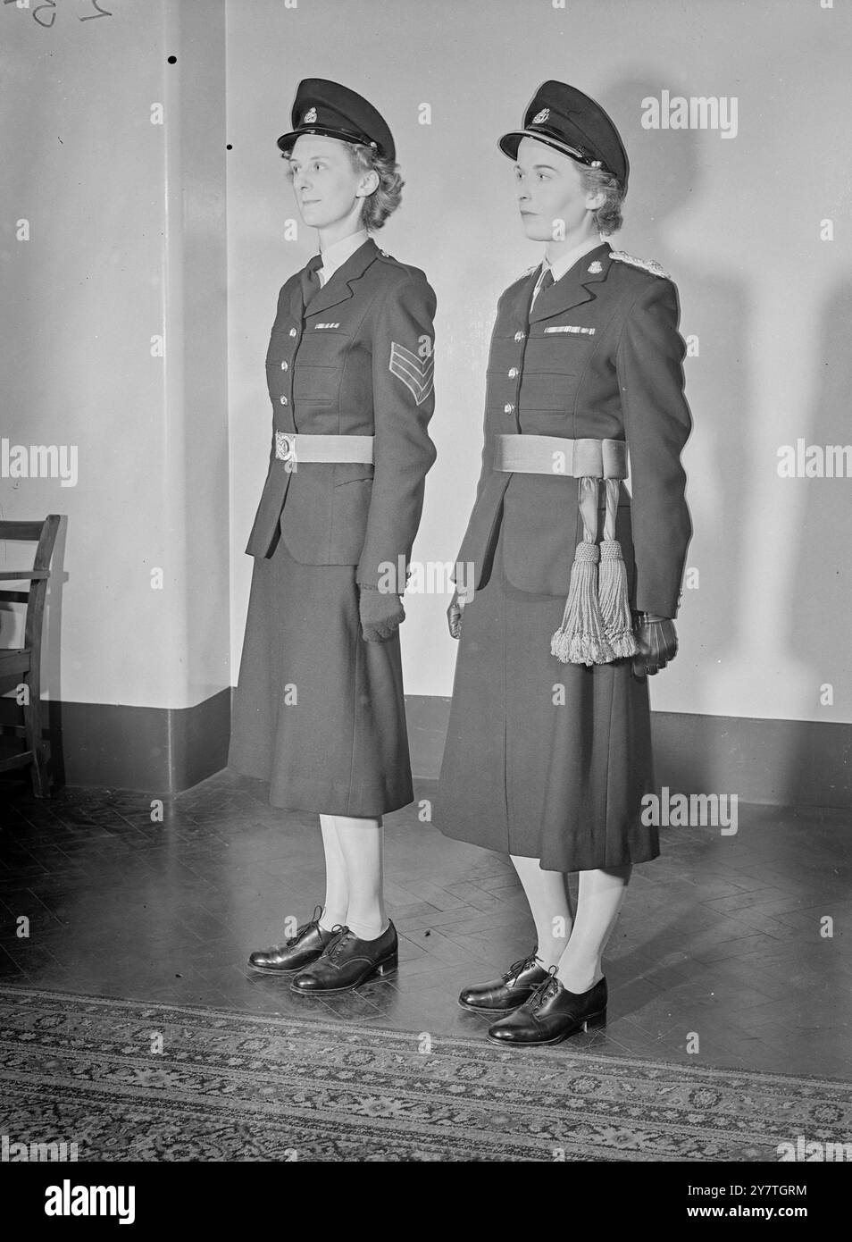 NEUE UNIFORMEN FÜR WRACS 4. November 1949 neue Uniformen für das Royal Army Corps der Frauen und das Royal Army Nursing Corps der Königin Alexandra wurden heute am Whitehall Place in London gezeigt. Die Uniformen wurden von Norman Hartnell, der Schneiderin der Königin, benannt. Das Bild zeigt: Die neue Uniform für WRAC-Offiziere (links) und andere Ränge. Es ist in flaschengrüner Barathea für Offiziere, serge in der gleichen Farbe für andere Ränge. Bei zeremoniellen Anlässen tragen Offiziere buchenbraune Rayonschürze und andere Ränge einen Gürtel aus buchenbraunem, leichtem Gurtband. Stockfoto