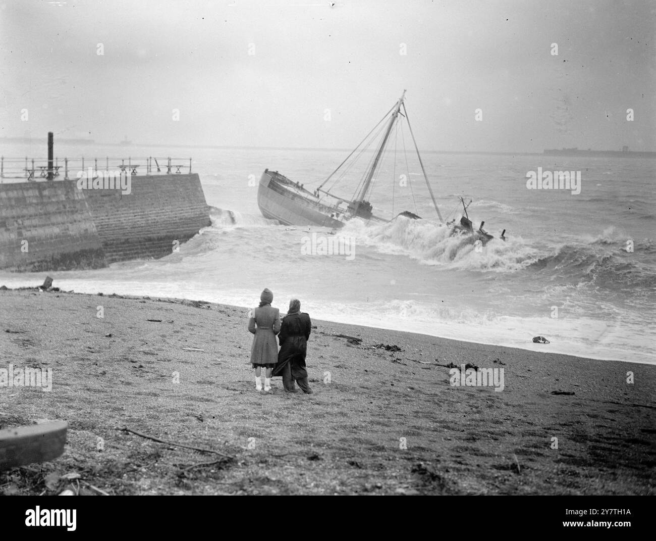 Der 250 Tonnen schwere britische Coastal Collier Arch Glenn wurde bei East Cliff, Dover, in dem schweren Sturm, der heute die Straße von Dover überfegte, an Land getrieben. Das Schiff, beladen mit Kohle, brach ihre Liegeplätze und wurde von rauer See an Land geschlagen, bis sie sich umdrehte und unter riesigen Wellen verschwand. Die Besatzungsmitglieder wurden mittels einer langen Leiter vom Schiff zu einem Steinsteg gerettet. DAS BILD ZEIGT: Raue Meere brechen über den Arch Glenn in Dover. Oktober 1949 Stockfoto