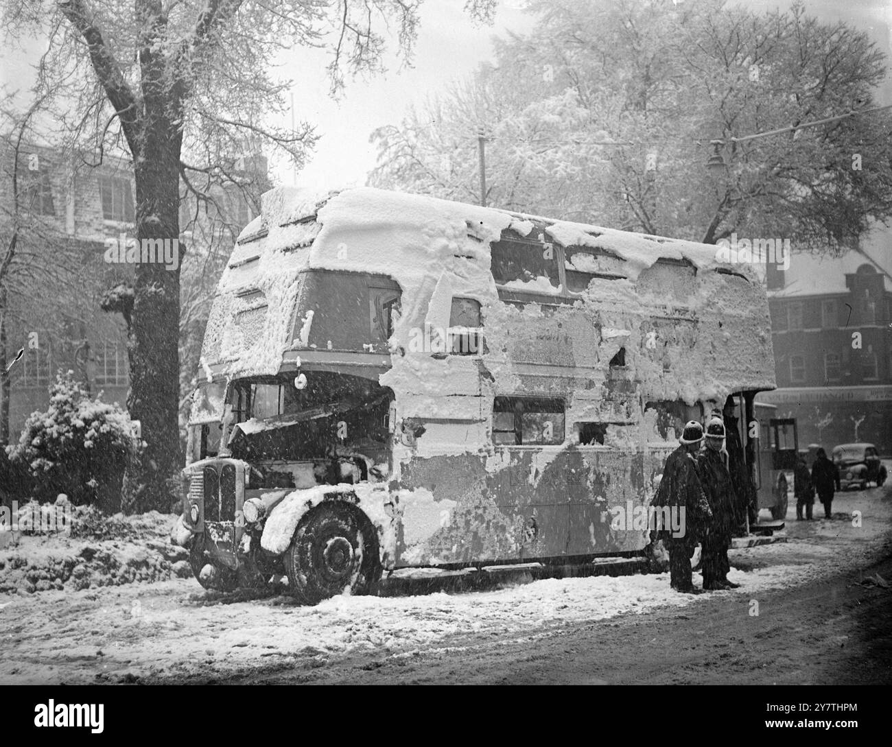 Acht im Krankenhaus nach einem Londoner Busunglück im Schnee. Schnee klammerte sich an der Seite eines Londoner Transportbusses Nr. 93, bei dem mehrere Menschen auf Wimbledon Hill, London, verletzt wurden. Der Bus , der auf der Schnee-, Eis- und schlammigen Fahrbahn schleuderte und umkippte, ist abgebildet, nachdem er von Pannenmännern wieder auf die Räder gesetzt worden war. 2. Januar 1951 Stockfoto