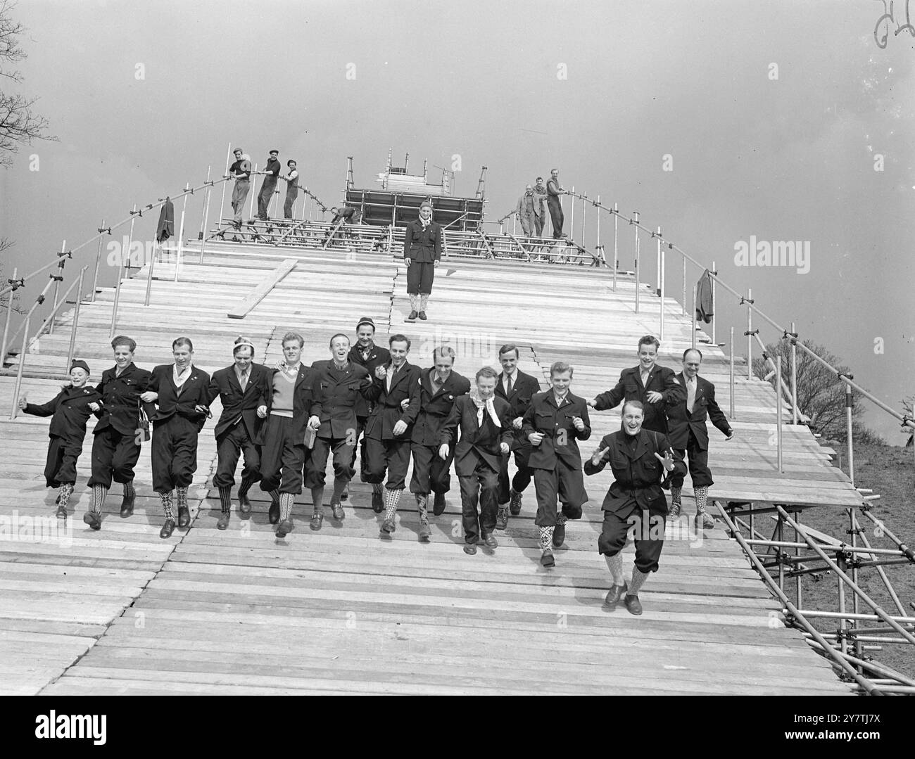 Das norwegische Skisprungteam zeigt uns, wie - auf Hampstead HeathLondon : einige Mitglieder des norwegischen Skisprungteams, das hierher gekommen ist, um die Skisprungabfahrt entlang der 62 Meter hohen Schanze (nach dem Vorbild des Holmenkellen Jump bei Oslo) zu demonstrieren, die auf der Heath gebaut wurde. 50 Tonnen Schnee wurden für die Demonstration gebracht. 21. März 1950 Stockfoto