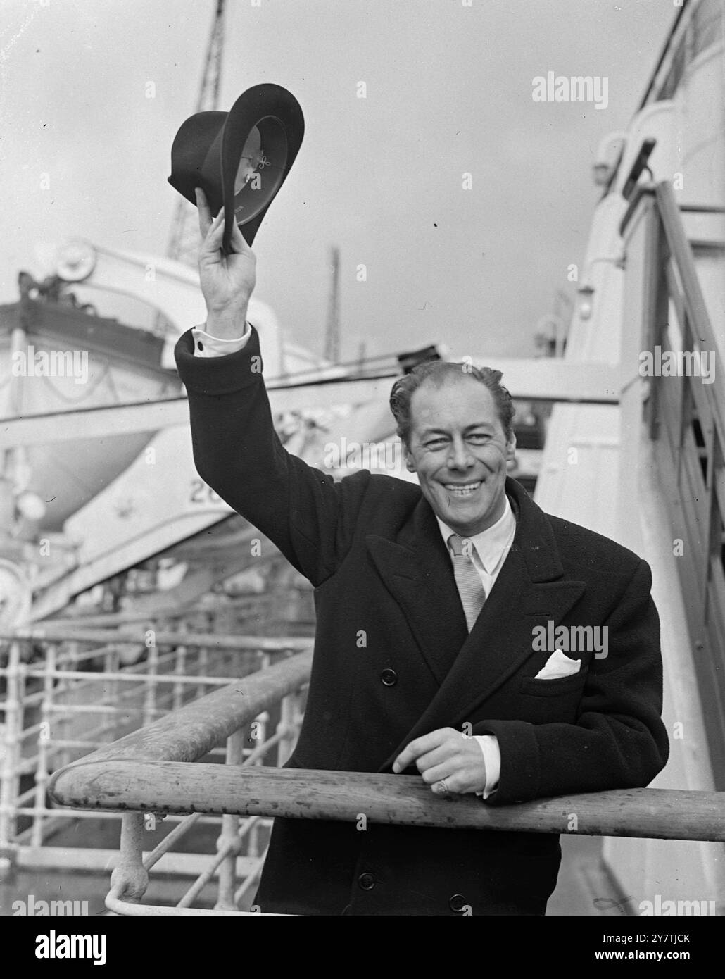 Southampton: Der britische Schauspieler Rex Harrison freut sich, wieder zu Hause zu sein und grüßt ihn bei seiner Ankunft hier an Bord der Queen Elizabeth. REX ist zurück, um die Führung in einem neuen Spiel im West End am .4. April 1950 zu übernehmen Stockfoto