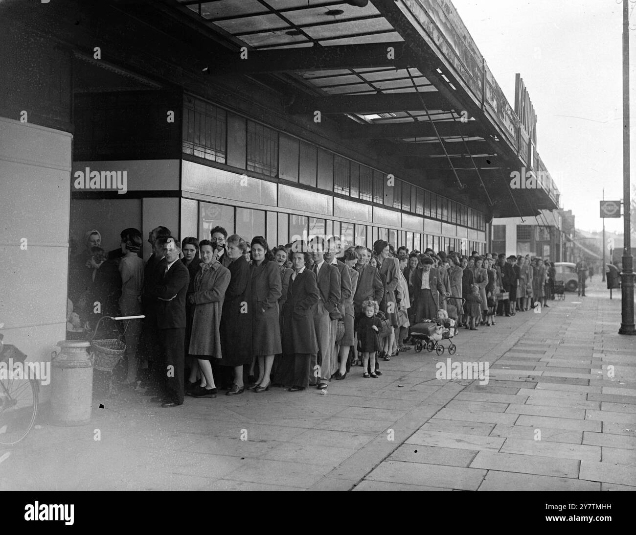Die ganze Nacht lang Schlange für Teppiche und Pyjamaseine Schlange von Hunderten von Menschen , von denen einige die ganze Nacht gewartet hatten , erstreckte sich entlang drei Seiten von Kennards Kaufhaus Wimbledon , in der Hoffnung, bei der Eröffnung des Geschäfts Teppiche und Teppiche ohne Gutscheine zu kaufen . Foto zeigt: Die lange Warteschlange vor dem Laden am 30. September 1946 Stockfoto