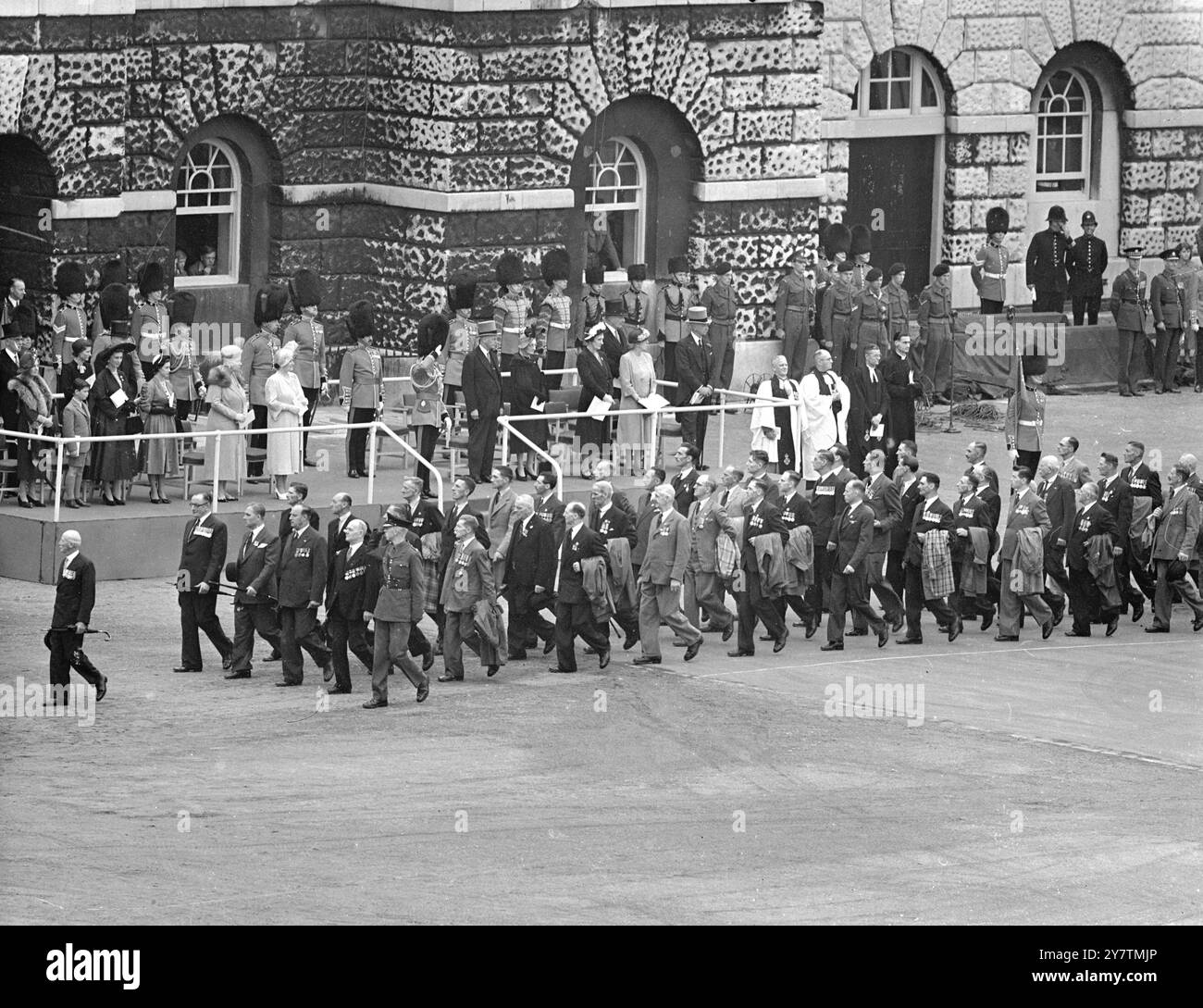 DER KÖNIG GRÜSST SIE BEI DER VERLEIHUNG DER FARBEN. - Die Szene auf der Pferdegardparade als König (mitten im Daiis) würdigt die Veteranen der Coldstream Guards während der Zeremonie, in der der König dem 3. Bataillon anlässlich des 300. Jahrestages der Bildung des Regiments neue Farben präsentierte. - Andere, die man auf der Straße sehen kann, sind (links) die Herzogin von Kent mit ihrem Sohn, Prinz Michael, und Prinzessin Margaret, Königin Maria und Königin. - 5. Juli 1950 Stockfoto