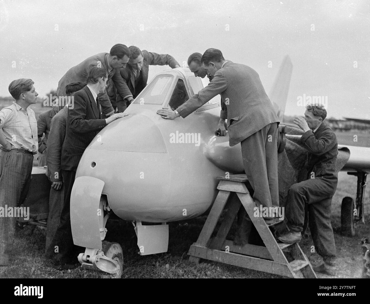 Großbritanniens neues schwanzloses Flugzeug hat Testflug - vielleicht schneller als Weltrekordflugzeug Großbritanniens neuestes Versuchsflugzeug, die de Havilland 108 ( The Swallow ), das über den Weltrekordkurs in der Nähe von Littlehampton geflogen werden soll, Sussex ' um wissenschaftliche Daten zu liefern', und einen vorläufigen Testflug in Hatfield, Herts. Die Swallow, die schneller als die Gloster Meteor-Doppeljet-Maschine ist, die den Weltrekord von 616 Stundenkilometern aufstellte, hat nach hinten geschwenkte Flügel und nicht das Schwanz. Er wird von einem einzigen hochgestuften de Havilland Goblin-Jet-Motor angetrieben. Foto zeigt: Inspektion des Cockpits von Stockfoto Großbritanniens neues schwanzloses Flugzeug hat Testflug - vielleicht schneller als Weltrekordflugzeug Großbritanniens neuestes Versuchsflugzeug, die de Havilland 108 ( The Swallow ), das über den Weltrekordkurs in der Nähe von Littlehampton geflogen werden soll, Sussex ' um wissenschaftliche Daten zu liefern', und einen vorläufigen Testflug in Hatfield, Herts. Die Swallow, die schneller als die Gloster Meteor-Doppeljet-Maschine ist, die den Weltrekord von 616 Stundenkilometern aufstellte, hat nach hinten geschwenkte Flügel und nicht das Schwanz. Er wird von einem einzigen hochgestuften de Havilland Goblin-Jet-Motor angetrieben. Foto zeigt: Inspektion des Cockpits von Stockfoto