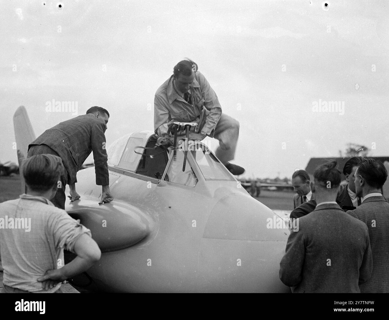 Großbritanniens neues schwanzloses Flugzeug hat Testflug - vielleicht schneller als Weltrekordflugzeug Großbritanniens neuestes Versuchsflugzeug, die de Havilland 108 ( The Swallow ), das über den Weltrekordkurs in der Nähe von Littlehampton geflogen werden soll, Sussex ' um wissenschaftliche Daten zu liefern', und einen vorläufigen Testflug in Hatfield, Herts. Die Swallow, die schneller als die Gloster Meteor-Doppeljet-Maschine ist, die den Weltrekord von 616 Stundenkilometern aufstellte, hat nach hinten geschwenkte Flügel und nicht das Schwanz. Er wird von einem einzigen hochgestuften de Havilland Goblin-Jet-Motor angetrieben. Foto zeigt: Inspektion des Cockpits von Stockfoto