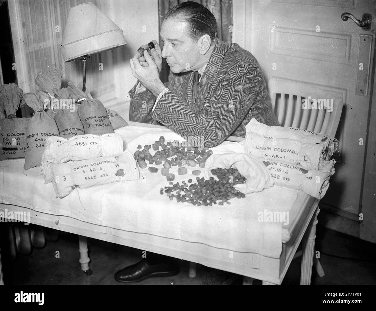 "EMERALD KING" HÄLT IM LONDONER HOTELZIMMER GLÜCK IN EDELSTEINEN Mr. Howard Hoeffer, 55 Jahre alter New Yorker Juwelier, wohnt in einem Londoner Hotel mit Smaragden im Wert von Hunderttausenden Pfund in einem alten Kleiderschrank in seinem Zimmer. Die 125 Pfund Rohsteine sind Proben des Produkts der Muza-Minen in Kolumbien, und Herr Hoeffer sagt, er habe zwei Jahre die gesamte Produktion der Minen gekauft - im Wert von etwa 1.000.000 Pfund. Die Minen wurden vor 14 Jahren geschlossen, aber ihre letzten zwei Jahre wurden in den Tresoren einer kolumbianischen Bank produziert. Herr Hoeffer hat zugesagt, bei der Finanzierung der Wiedereröffnung der Minen mitzuhelfen Stockfoto