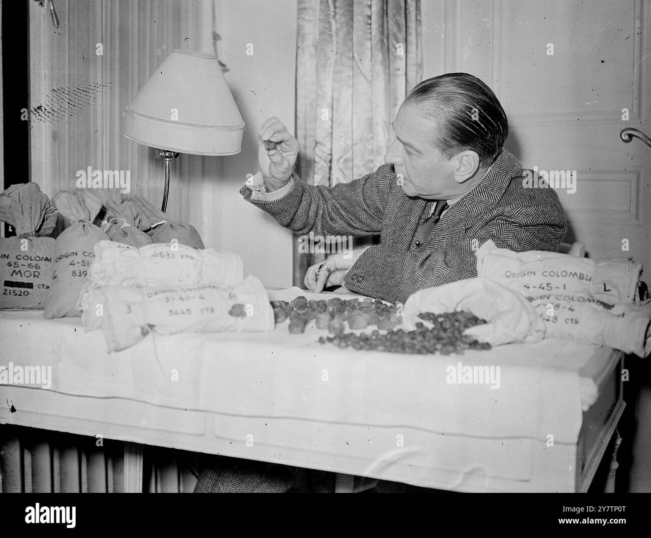 "EMERALD KING" HÄLT IM LONDONER HOTELZIMMER GLÜCK IN EDELSTEINEN Mr. Howard Hoeffer, 55 Jahre alter New Yorker Juwelier, wohnt in einem Londoner Hotel mit Smaragden im Wert von Hunderttausenden Pfund in einem alten Kleiderschrank in seinem Zimmer. Die 125 Pfund Rohsteine sind Proben des Produkts der Muza-Minen in Kolumbien, und Herr Hoeffer sagt, er habe zwei Jahre die gesamte Produktion der Minen gekauft - im Wert von etwa 1.000.000 Pfund. Die Minen wurden vor 14 Jahren geschlossen, aber ihre letzten zwei Jahre wurden in den Tresoren einer kolumbianischen Bank produziert. Herr Hoeffer hat zugesagt, bei der Finanzierung der Wiedereröffnung der Minen mitzuhelfen Stockfoto