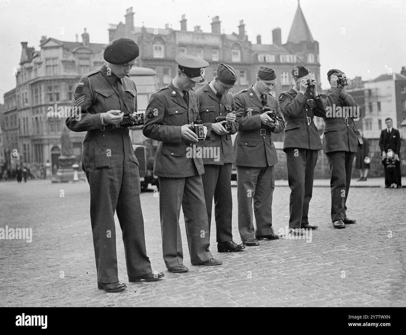 AMERIKANISCHE UND DOMINION-TRUPPEN BESUCHEN SCHLOSS WINDSOR Eine Gruppe von Soldaten und Fliegern aus den Vereinigten Staaten, Kanada, Neuseeland und Britisch-Honduras, besuchte Schloss Windsor auf einer Besichtigungstour. Fotoshows: Einige der Besucher fotografieren das Schloss als Souvenir an ihren Besuch. (Von links nach rechts): Sergeant John Monk aus Ottowa, Kanada; Corporal John Young aus Scarsdale, New York, USA; AC W C Browning aus New Westminster, British Columbia, Kanada; Corporal Alfred Monikowski aus Buffalo, New York, USA; Sergeant Pilot, R Hayward, aus Auckland, Neuseeland und Sergeant Pilot D Stockfoto