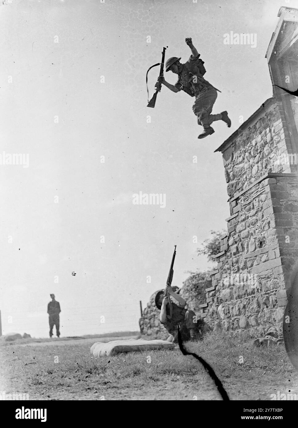 VERSTÄRKUNG DES KURSES FÜR MÄNNER DES RAF-HEERESKOMMANDOS Männer des RAF-Heereskooperationskommandos, einschließlich Boden- und technischem Personal wie Klempner, Köche, Metzger, Meteorologen und Telefonisten, durchlaufen einen „Aufwärtskurs“ an einer Station des RAF-Heereskooperationskommandos. Diese Männer überwinden Hindernisse unter Beschuss mit voller Ausrüstung, während sie den Kurs durchlaufen, und müssen sich unter anderem durch Stacheldrahtzwicklungen durchdringen. Jeder Mann, der langsam ist oder zurückbleibt, kann eine Bombe unter seinen Füßen platzen lassen. Fotoshows: Ein Teilnehmer im „Toughen Stockfoto