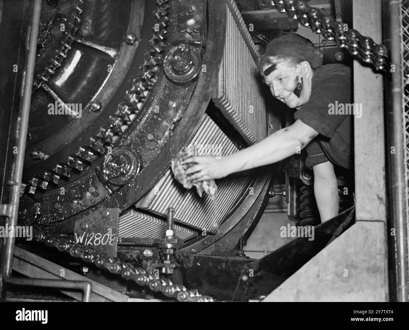 SIE ist EINE ROLLTREPPE GREASER die neuesten Rekruten von London Transport's Armee von weiblichen Kriegsarbeitern sind Greaser für Rolltreppen. Die Aufgabe ist extrem schmutzig, und die Frauen werden daher mit Overalls und Kopfbedeckungen versehen. Sie arbeiten in Viererbanden unter einem männlichen Vorgesetzten. Foto zeigt: Eine der Frauen, die eine Rolltreppe am Bahnhof Swiss Cottage fetten. Die Arbeiten werden nur nachts ausgeführt, wenn die Maschine ruht. 27. Dezember 1941 Stockfoto