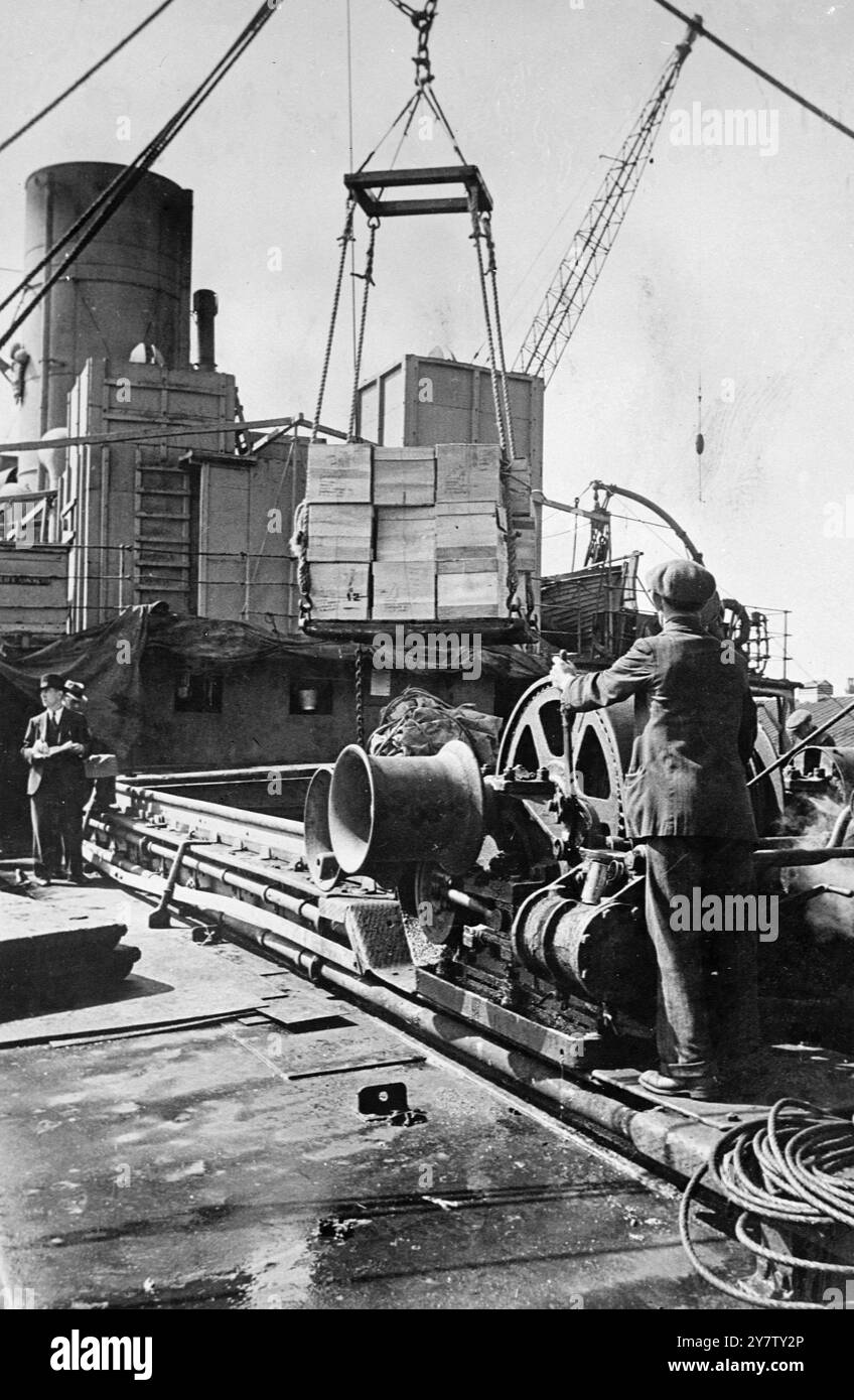 LEBENSMITTEL AUS AMERIKA KOMMEN IN GROSSBRITANNIEN AN Foto zeigt: Schachteln mit Schmalz werden aus dem Frachtraum eines britischen Schiffes gezogen, das eine Ladung aus getrockneter Milch, Mehl, kanadischem Weizen, Käse, Schmalz-Rotes Kreuz-Waren und anderen Waren aus Amerika mitgebracht hat. Einige der Waren wurden unter dem Lease Lend Bill verschickt, andere vom amerikanischen Volk. Stockfoto