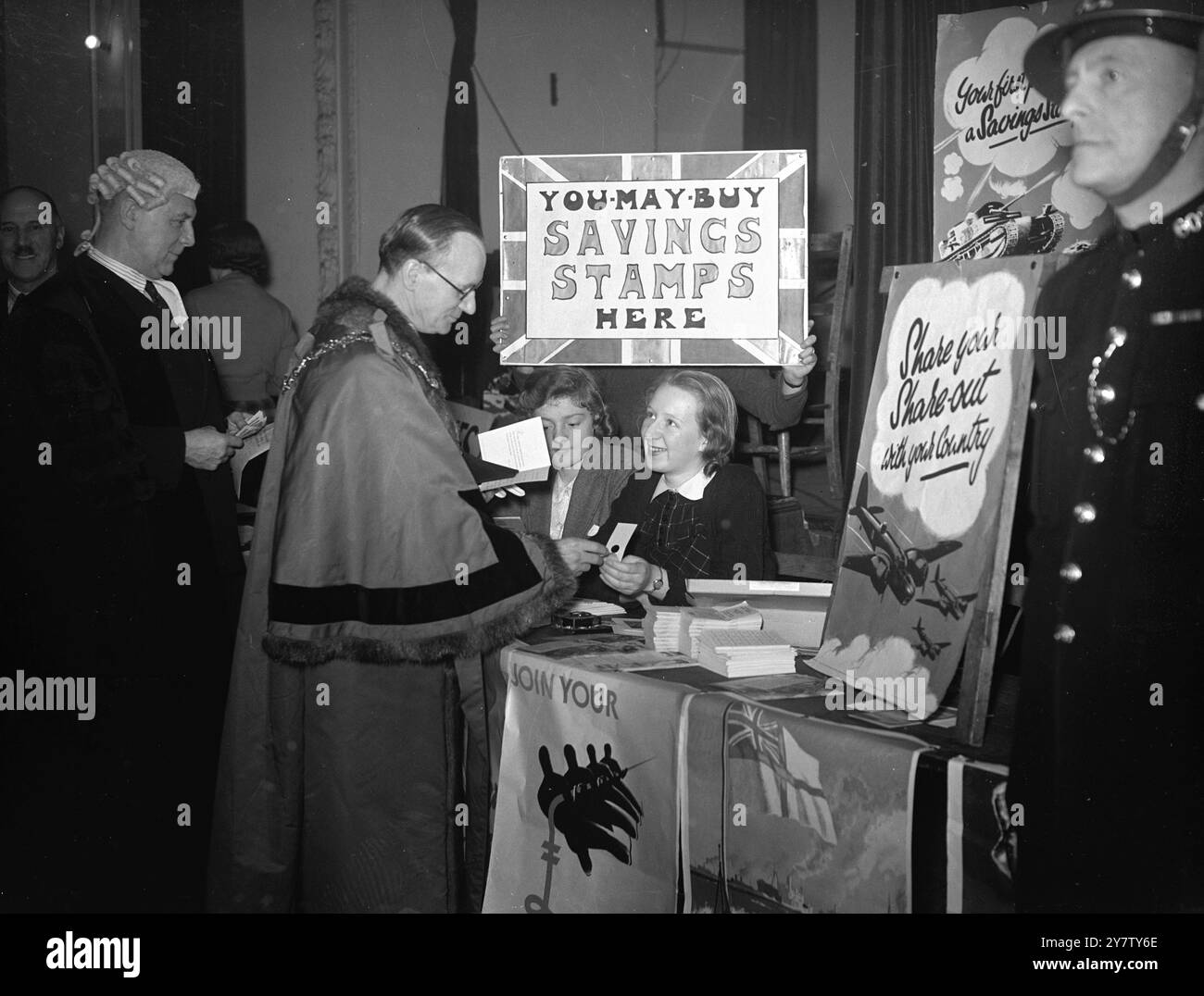 DIE LONDONER VERTEILEN SICH AUF 60 000 PFUND Ein Anteil von 60 000 Pfund wurde in Hammersmith von der Broadway Congregational Friendly Society gemacht. Der Bürgermeister von Hamersmith, Stadtrat R H Kent, half bei der Verteilung des Geldes an seine Vorgänger und andere Stadträte, die Mitglieder der Gesellschaft waren. Foto zeigt: Der Bürgermeister von Hammersmith, Stadtrat Richard Henry Kent, kauft nach Erhalt seines Anteils Kriegs-Sparscheine. 19. Dezember 1940 Stockfoto