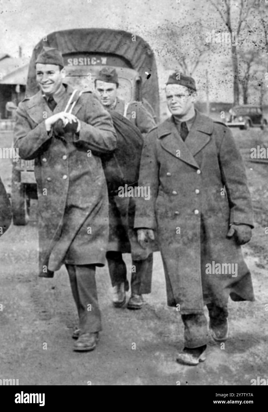 Das Foto zeigt: Winthrop Rockefeller (rechts) der 28-jährige Sohn von John D Rockefeller Junior, dem Millionär in Privatuniform gekleidet und andere Kleidung getragen, die ihm in Fort Dix, New Jersey, ausgestellt wurde. Winthrop Rockefeller, der freiwillig beitrat, hatte nur eine Beschwerde - dass sein Hemd zu kurz war. 12. Februar 1941 Stockfoto