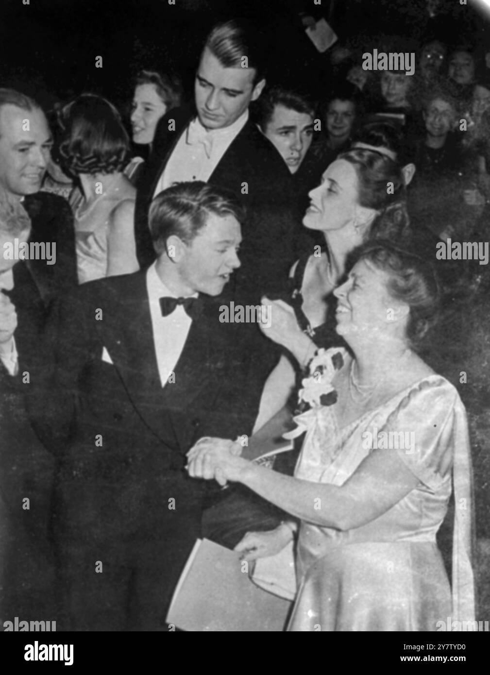 MICKEY ROONEY TRIFFT DIE FRAU DES PRÄSIDENTEN BEI DER ERÖFFNUNGSGALA Fotoshows: Frau Franklin D Roosevelt, die Frau des Präsidenten, schüttelt die Hand mit Mickey Rooney, dem jungen Filmkomiker, der an der Einweihungsgala in der Constitutional Hall in Washington DC teilnahm. Hinter Frau Roosevelt steht ihre Tochter John Boettiger und hinter Mickey Rooney ist John Roosevelt. 11. Februar 1941 Stockfoto