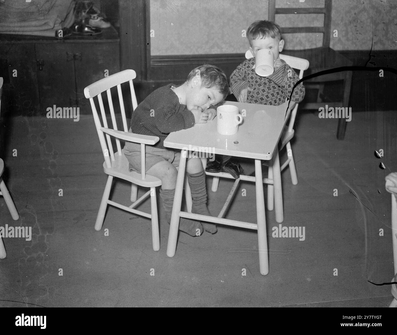 MILK AND REST LONDON's BLITZ BABIES FINDEN FRIEDEN AUF DEM LAND Ein Zuhause, Syston Court, ein schönes altes tudor-Herrenhaus in Gloucestershire, wurde für Londoner Kinder im Alter von einem Monat bis fünf Jahren, die Opfer von Nerven durch Luftangriffe wurden, durch Mittel des Alliierten Hilfsfonds zur Verfügung gestellt. Die meisten Kleider für die Kinder wurden vom amerikanischen Roten Kreuz bereitgestellt. Lady Gumton, Frau des Parlamentsabgeordneten von Thornbury, war für die Vorkehrungen verantwortlich und empfing die Kinder, von denen die meisten seit Wochen nicht mehr aus ihren Unterkünften gegangen sind. Foto zeigt: Johnnie Wragg (mit dem Kopf auf dem Arm) Stockfoto