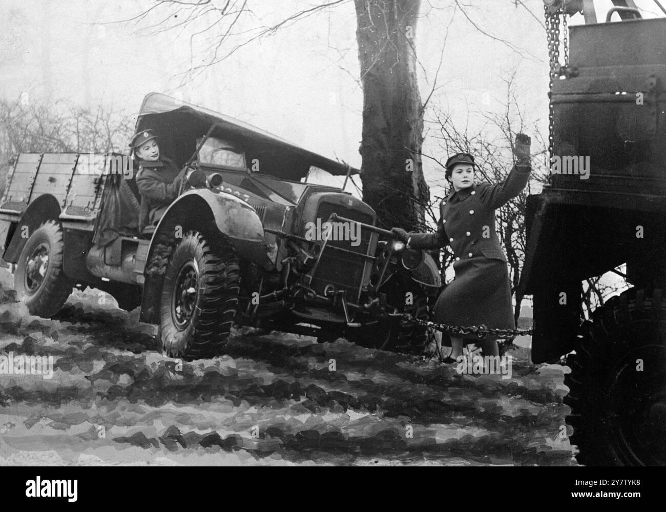 ATS-MÄDCHEN, DIE IM LAGER DES NORDENKOMMANDOS ALS LKW-FAHRER AUSGEBILDET WURDEN ATS-Mädchen werden in einem Lager in Nordengland ausgebildet, um schwere LKW-Fahrzeuge zu fahren, von denen einige zehn Tonnen wiegen und Anhänger tragen. Die Hauptaufgabe für die Mädchen ist die Überführung der neuen Lastkraftwagen zu Einheiten in ganz Großbritannien im Konvoi. Die Ausbildung dauert drei Wochen und das Alter der Mädchen liegt zwischen 18 und 43 Jahren. Das Foto zeigt: Ein Fahrzeug wird mit Hilfe eines anderen Militärlagers wieder auf die Straße gebracht. 31. Januar 1941 Stockfoto