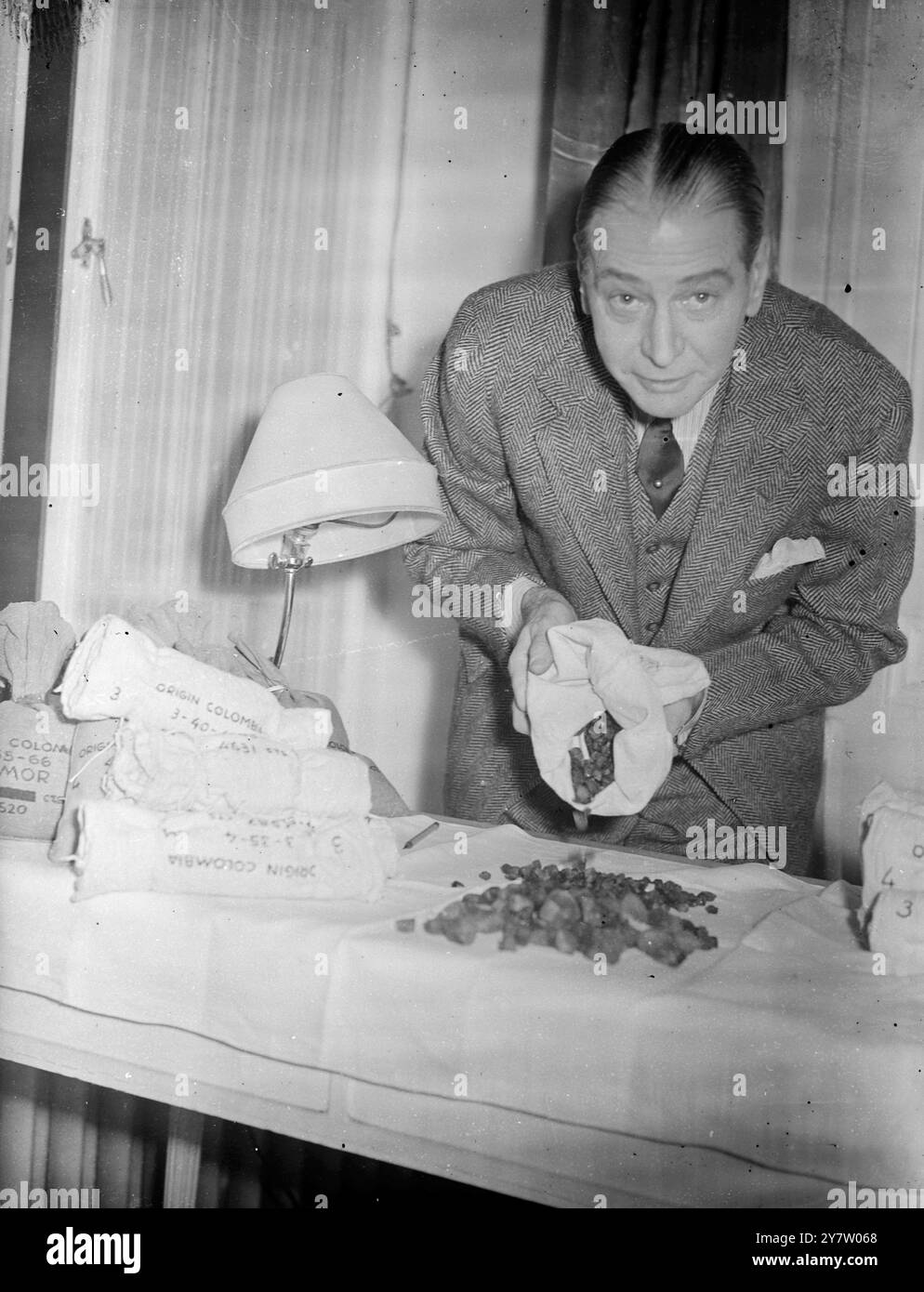 "EMERALD KING" HÄLT IM LONDONER HOTELZIMMER GLÜCK IN EDELSTEINEN Mr. Howard Hoeffer, 55 Jahre alter New Yorker Juwelier, wohnt in einem Londoner Hotel mit Smaragden im Wert von Hunderttausenden Pfund in einem alten Kleiderschrank in seinem Zimmer. Die 125 Pfund Rohsteine sind Proben des Produkts der Muza-Minen in Kolumbien, und Herr Hoeffer sagt, er habe zwei Jahre die gesamte Produktion der Minen gekauft - im Wert von etwa 1.000.000 Pfund. Die Minen wurden vor 14 Jahren geschlossen, aber ihre letzten zwei Jahre wurden in den Tresoren einer kolumbianischen Bank produziert. Herr Hoeffer hat zugesagt, bei der Finanzierung der Wiedereröffnung der Minen mitzuhelfen Stockfoto