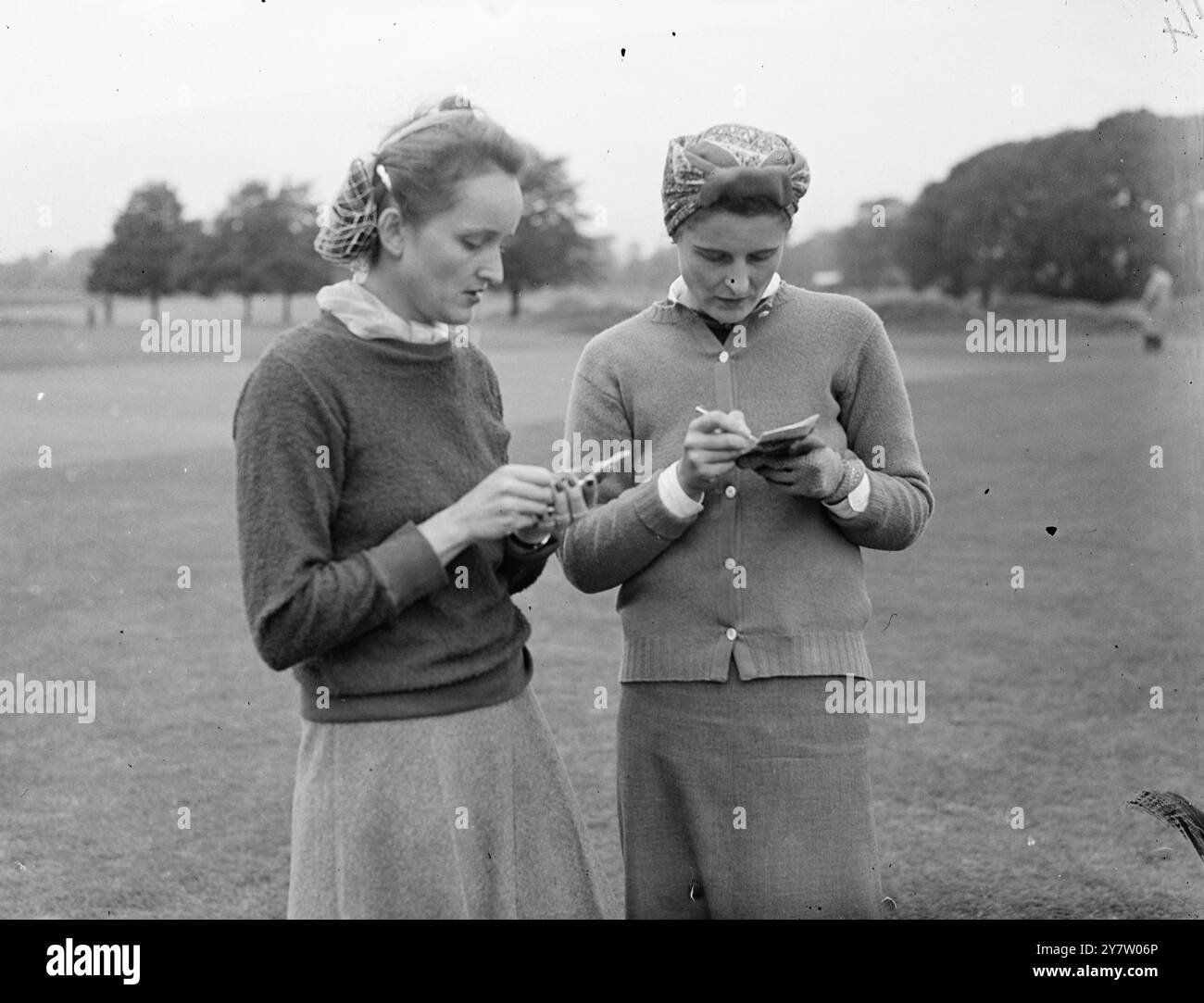 DIE ERSTE amerikanische GOLFSPIELERIN IN GROSSBRITANNIEN SEIT 1939 – SPIELT BEIM NATIONALEN TURNIER die erste amerikanische Golfkonkurrentin, die seit sieben Jahren nach Großbritannien kam, Miss Ruth Woodward aus Fall River, Massachusetts, nahm am Womens National Tournament auf dem Royal Mid Surrey Course in Richmond Teil. Miss Woodward kehrte 88 zurück, ihre Partnerin Mrs. Gabrielle Style 82. Mr. Style, ein Schüler von Archie Compston, hat ein Handicap von zwei. Fotoshows: Miss Ruth Woodward (links) und Frau Gabrielle Style, die ihre Ergebnisse nach der Runde überprüfen. 13. September 1946 Stockfoto