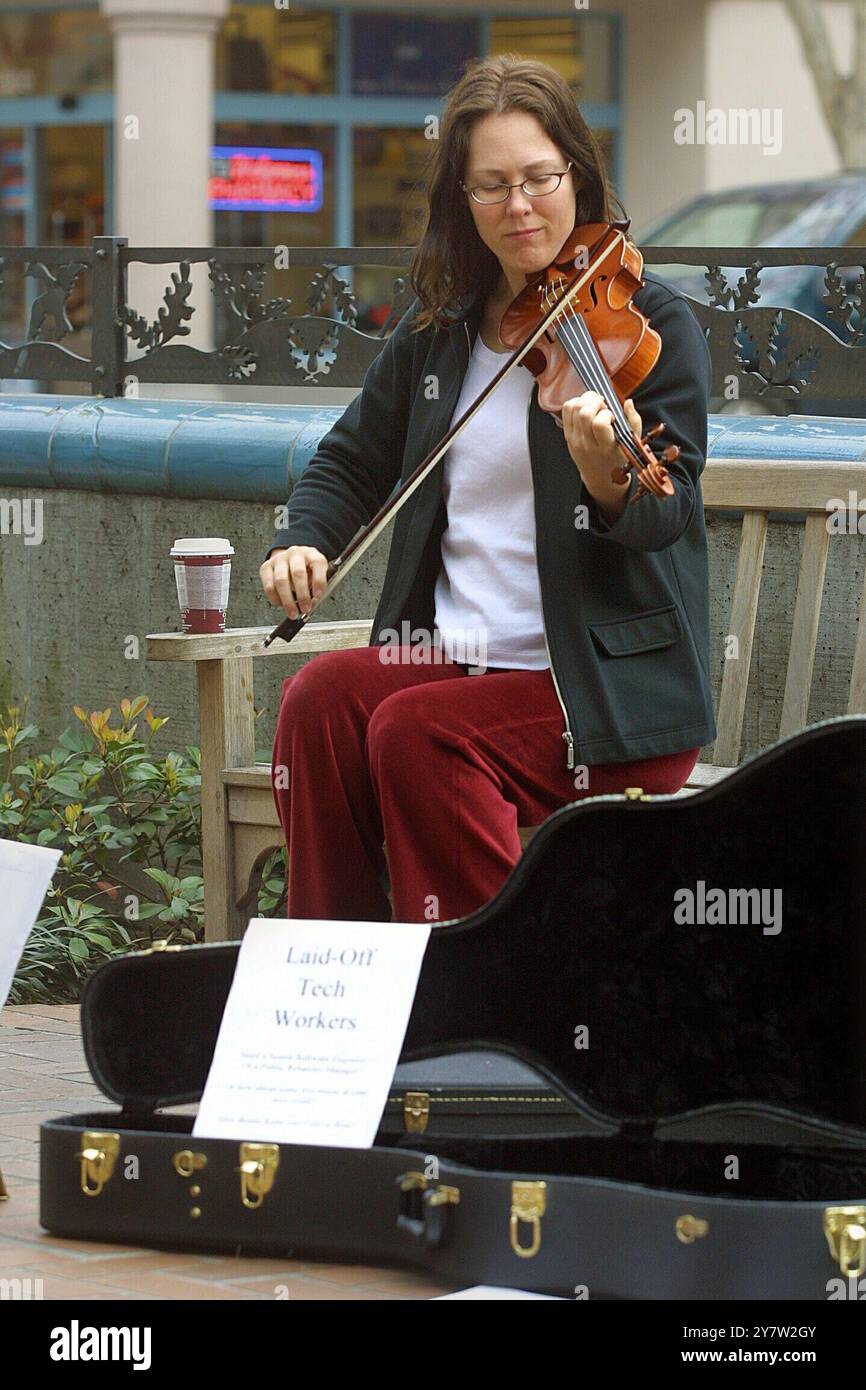 Palo Alto, Kalifornien, Valarie Price, eine entlassene Software-Ingenieurin aus Belmont, Kalifornien, die heute Passanten auf der University Avenue in der Innenstadt von Palo Alto mit keltischer Musik und Lebensläufen betreibt. Sie hofften, High-Tech-Führungskräfte beim Mittagessen ins Auge zu fassen. Also keine Stellenangebote, aber es ist besser, als zu Hause auf das Klingeln des Telefons zu warten. Sie haben andere Arbeitslose kennengelernt, die ihren Geistern helfen. Foto am Freitag, 15. Februar 2002. ) Stockfoto