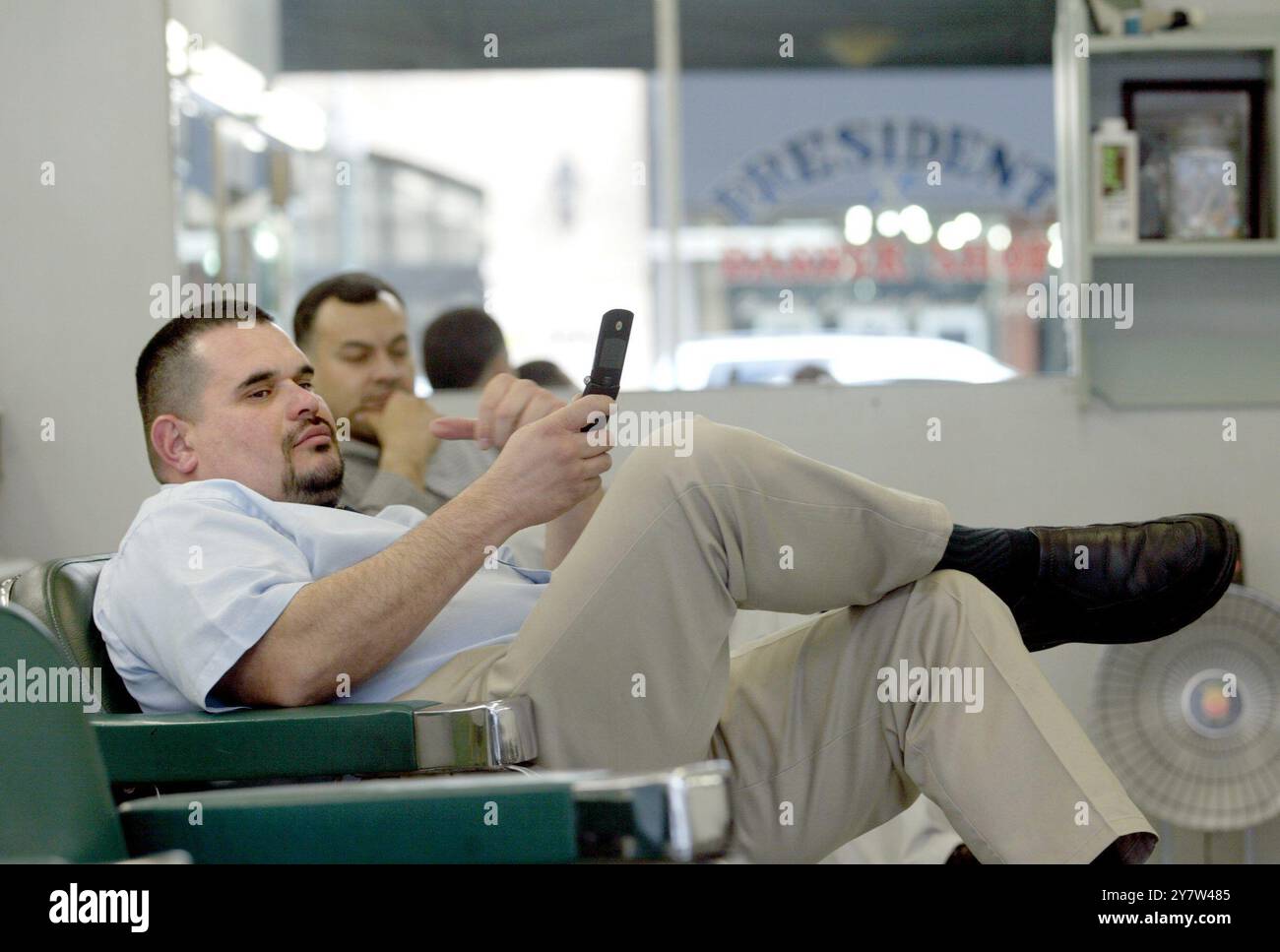 PALO ALTO, KALIFORNIEN .,--Präsident Barber Shop Friseur lädt einige Spiele auf sein Handy herunter, während er am Dienstag, den 14. Februar 2006 auf Kunden wartet. Stockfoto