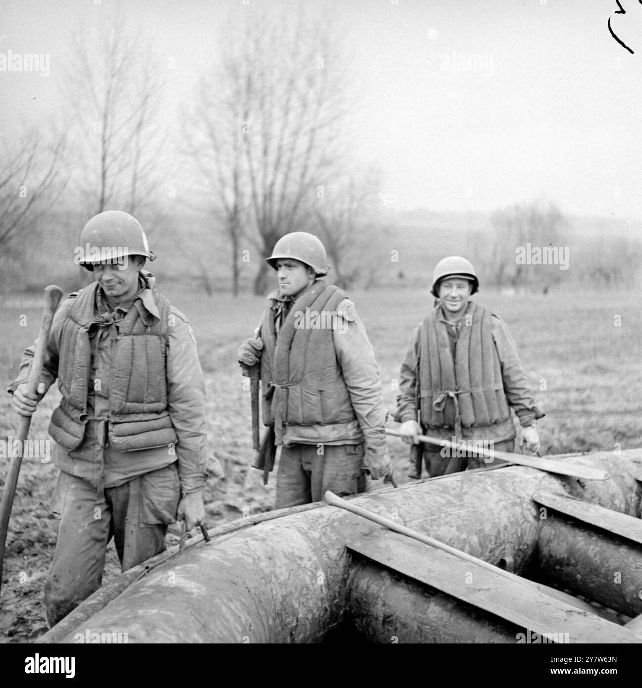 VERBÜNDETE INTENSIVIEREN FLUSSQUERUNGEN WESTLICH DES RHEINS mit britischen, kanadischen und amerikanischen Truppen, die den Rhein von Arnheim nach Coblenz überblicken, und der Brückenkopf bei Remagen wächst täglich, haben die Alliierten westlich der letzten natürlichen Verteidigungslinie Deutschlands an der Westfront intakte Flussquerungen gemacht. Foto zeigt: Siebte Armee-Angriffstruppen Proben einen Fluss, der westlich des Rheins überquert. Von links nach rechts, mit ihrem Schlauchboot, befinden sich der private First Class Osmus Leonard von 322 Alameda Avenue, Astoria, Oregon T/5 Elmore Scafibel, aus Natalbany, Louisian, und Sergeant George Prengress von A Stockfoto