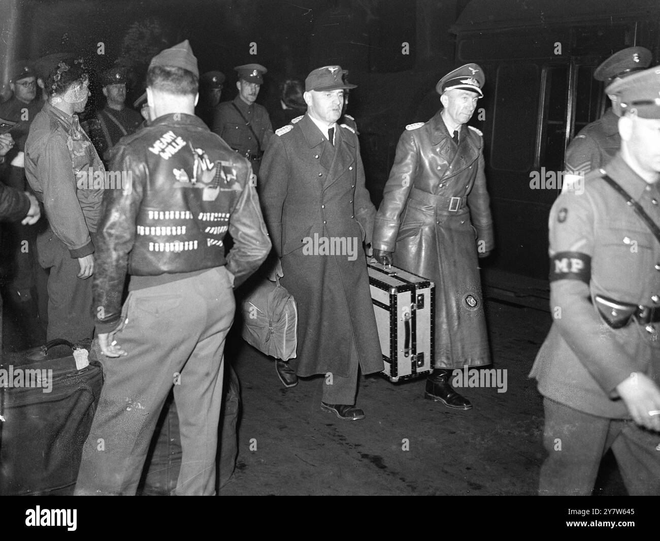 DEUTSCHE GENERÄLE IN LONDON Foto zeigt: Major General Muller (links) und Major General Maier von der deutschen Armee, übergeben einen der Männer, die das Reich besiegt haben, während sie sich auf den Bahnhof Euston vorbereiten. Er ist technischer Sergeant J B Alexander aus Rhode Island, New York, Funkbetreiber des Bombers „Weary Willie“. Bomben auf seiner Fliegerjacke zeigen die Anzahl seiner Missionen. 17. Mai 1945 Stockfoto DEUTSCHE GENERÄLE IN LONDON Foto zeigt: Major General Muller (links) und Major General Maier von der deutschen Armee, übergeben einen der Männer, die das Reich besiegt haben, während sie sich auf den Bahnhof Euston vorbereiten. Er ist technischer Sergeant J B Alexander aus Rhode Island, New York, Funkbetreiber des Bombers „Weary Willie“. Bomben auf seiner Fliegerjacke zeigen die Anzahl seiner Missionen. 17. Mai 1945 Stockfoto