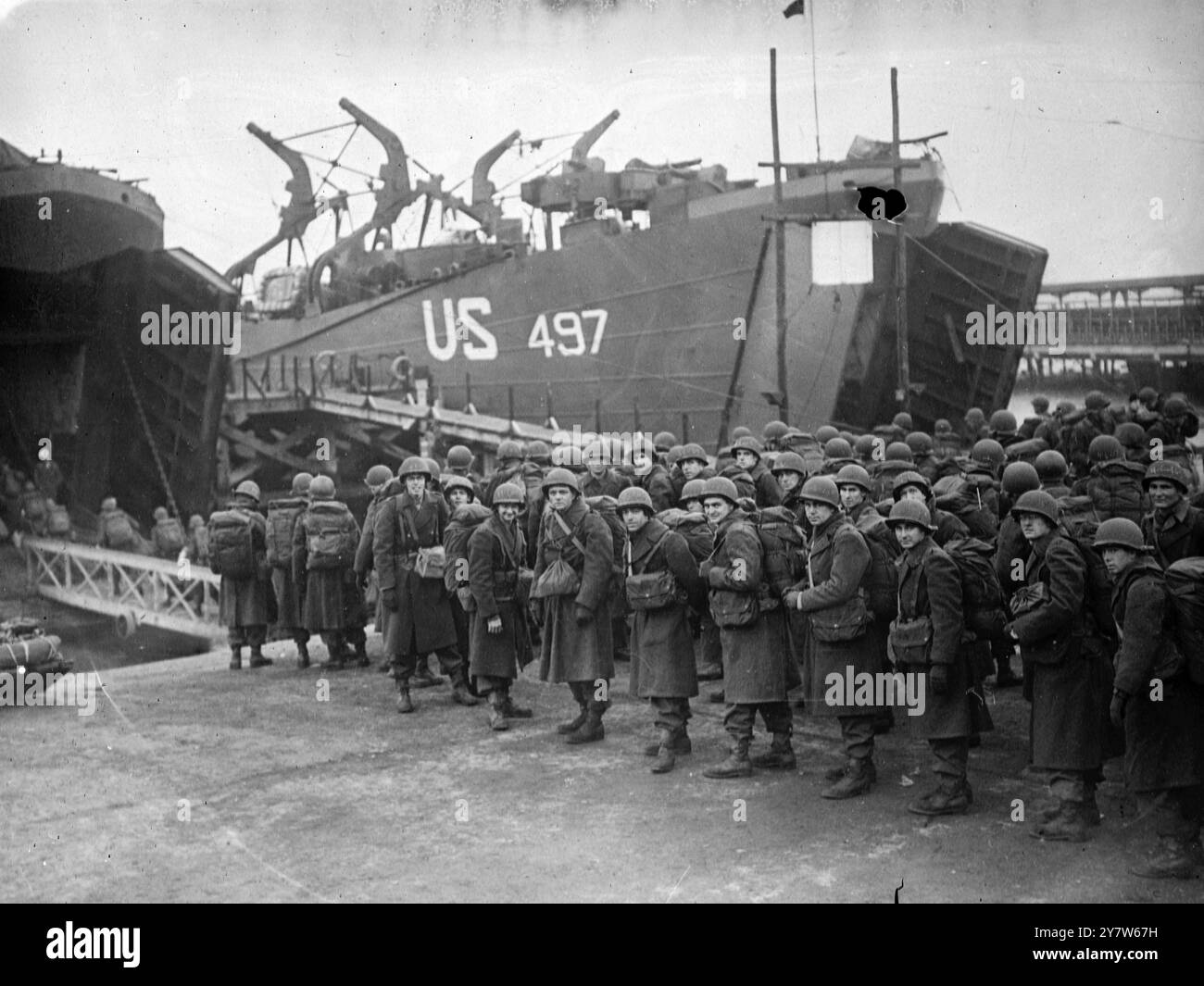 AMERIKANISCHE VERSTÄRKUNGEN FÜR DIE WESTFRONT VERLASSEN ENGLAND. Foto zeigt: Amerikanische Verstärkung der Westfront, die in einem britischen Hafen Landungsboote einschiffen. Die meisten der Männer waren nur für kurze Zeit in England. 16. Januar 1945 Stockfoto
