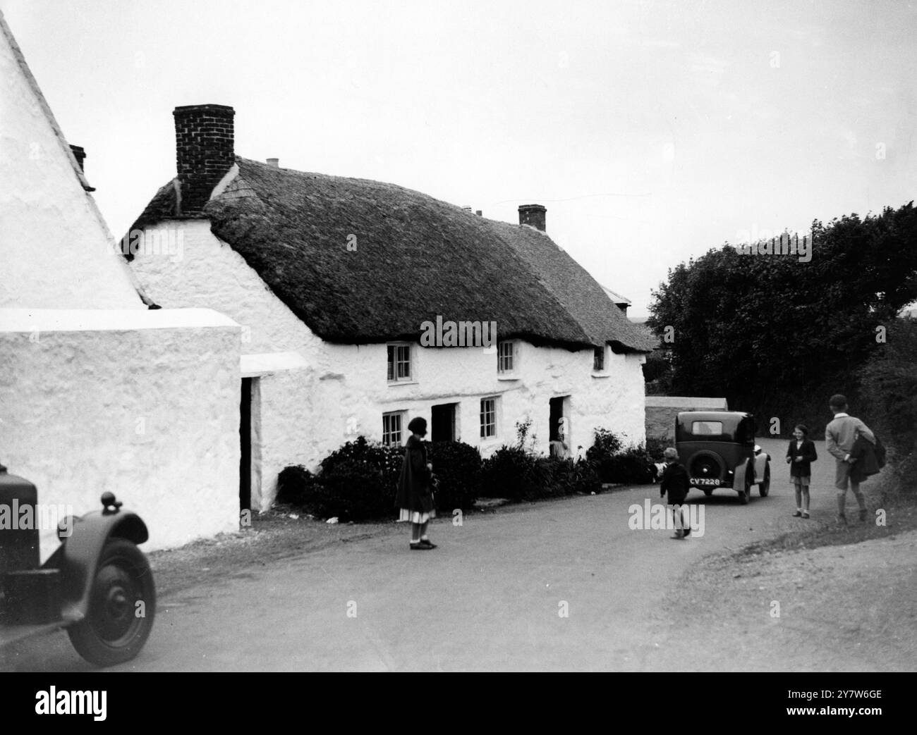 Kinder spielen auf der Straße vor ihrem kornischen Häuschen, Mullion, Cornwall. England. Stockfoto