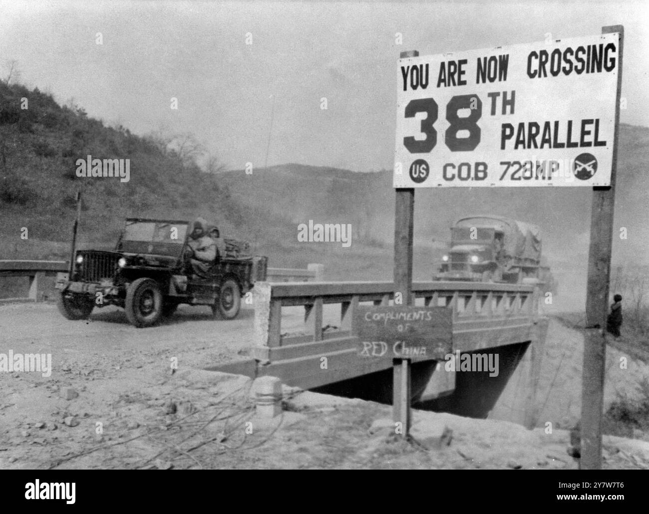 Koreanische WarUN-Fahrzeuge, die während des heutigen Rückzugs von den chinesischen Horden über eine Brücke an der 38. Parallelgrenze fahren, treffen auf dieses Schild mit der Aufschrift " mit Komplimenten von Rotem China " am 17. Dezember 1950 Stockfoto