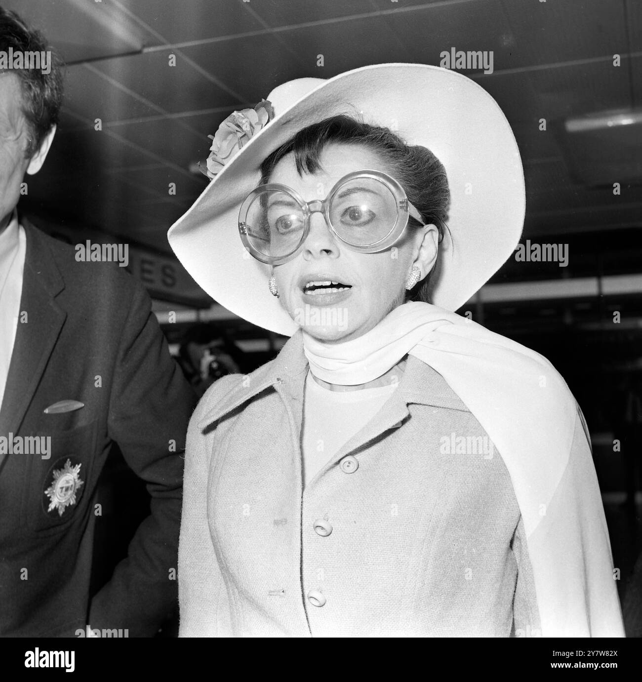 " IRGENDWO ÜBER DEM REGENBOGEN "... Amerikas eigener Sänger JUDY GARLAND , die als Teenager-Star in dem Film, in dem sie " irgendwo über dem Regenbogen " sang, weltberühmt wurde, wird dargestellt, als sie gestern Abend den Londoner Flughafen Heathrow auf einer Geschäftsreise nach New York verließ . Sie wurde von ihrem Mann Mickey Deans begleitet . Für die Reise trug Judy ein schickes Reiseoutfit , eine große Hornbrille und einen fließenden Schal . 1969 2019 neue Filmstars Renee Zellweger als Judy Stockfoto