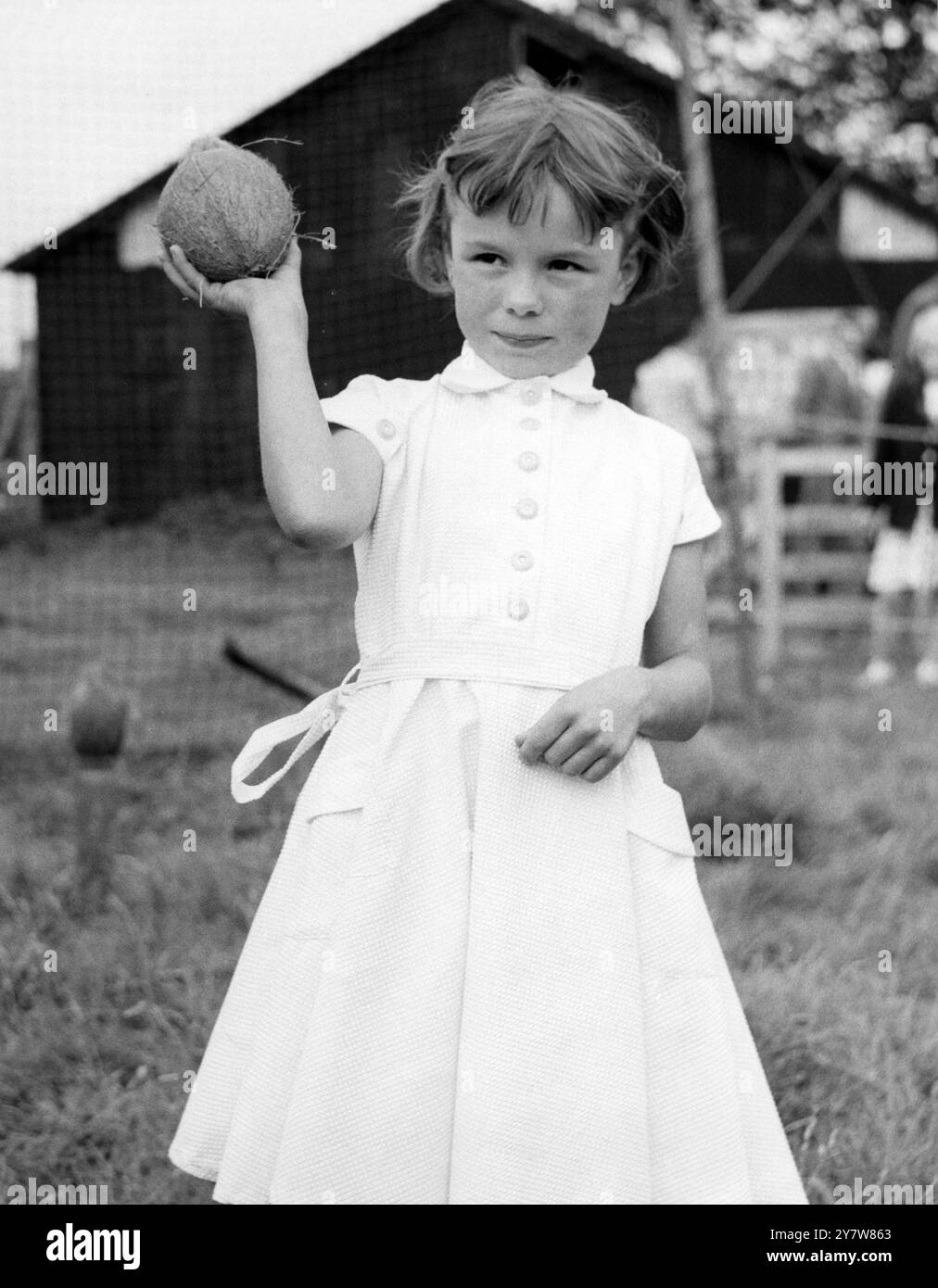 Little Rita Smith (6) war fast genauso überrascht wie die Stallerin und Zuschauer auf einem fest in der Hodsoll Street (nahe Meopham), Kent, als sie die Kokosnuss niederschlug und gewann. - 22. August 1957 Stockfoto