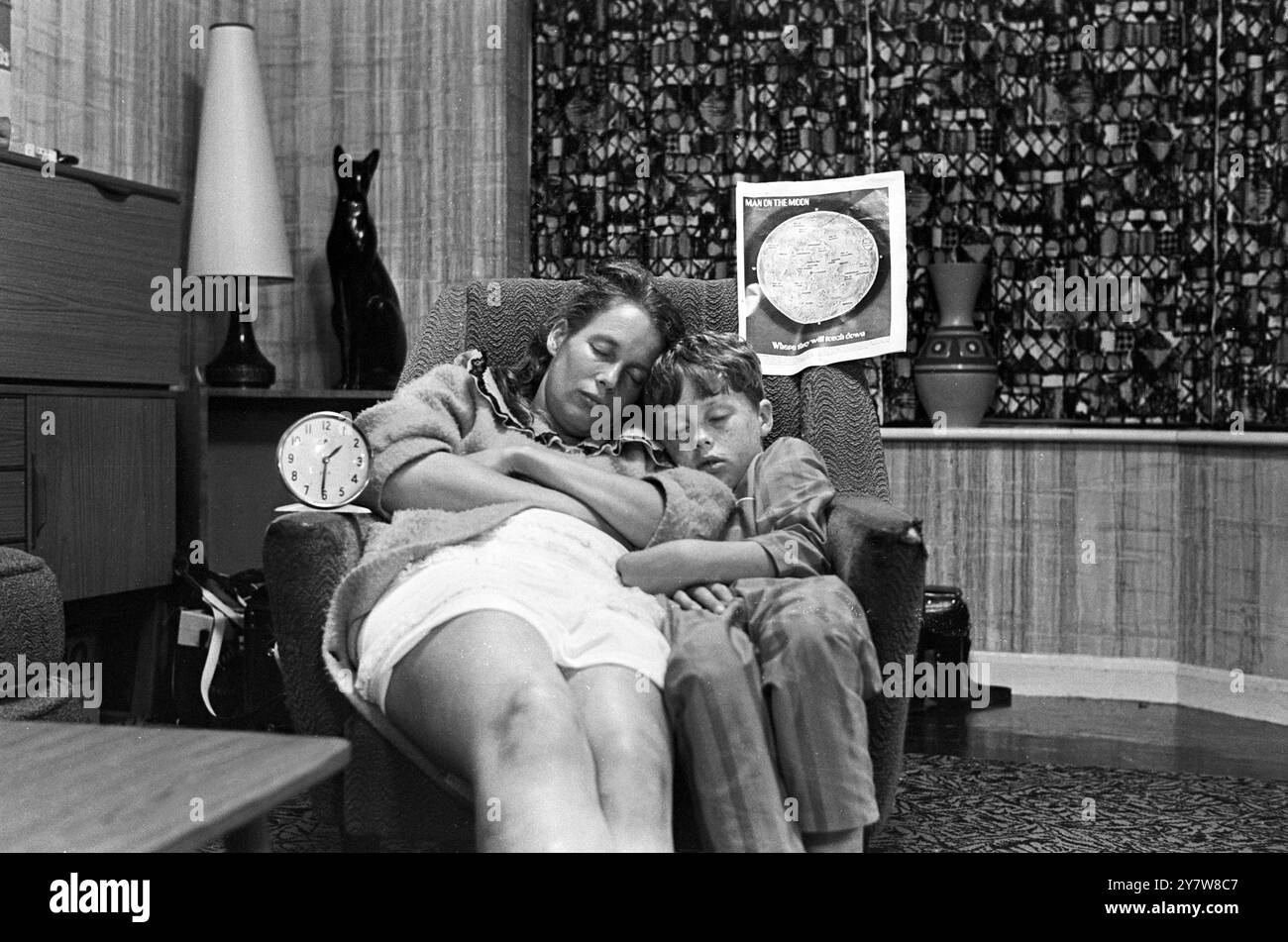 Shirley Sayers und ihr Sohn Nigel machen ein Nickerchen, bevor der Mensch seinen ersten Schritt auf dem Mond macht. Die Familie des UPI-Fotografen Maurice Sayers setzte einen Alarm am Sessel, nur für den Fall, dass sie alle eindöschen und das bedeutsame Ereignis im Fernsehen verpassten. Neil Armstrong hat die Mondoberfläche kurz vor 4 Uhr UK-Zeit durchgeschossen. Brighton, Sussex, England - 21. Juli 1969 Stockfoto