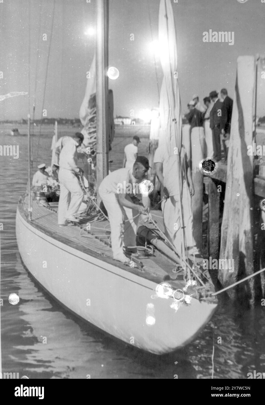 ZEPTRE ZURÜCK AUF SEE Newport, Rhode Island: Ein Besatzungsmitglied der britischen Yacht 'Sceptre' bereitet sich darauf vor, als britischer Herausforderer für den America's Cup die Buglinie abzuwerfen, verlässt die Werft von Newport gestern nach Reparaturen an den Schäden, die durch das Abziehen des vorderen Stages (unter der Wasserlinie auf Bug) verursacht wurden. 10. September 1958 Stockfoto