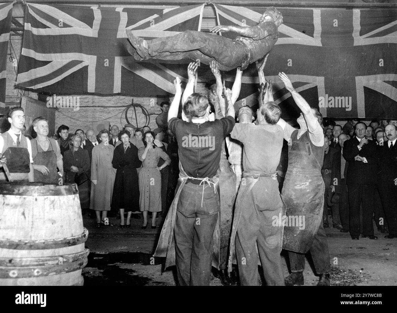 PRÜFUNG DURCH FEUER UND WASSER FÜR COOPERS LEHRLING ... - - - - - - - seit Königin Elisabeth I. wurde ein Lehrling im Genossenschaftsgewerbe nach Abschluss seiner Lehre in ein eigenes Fass gebündelt und von seinen Mitstreitern mit einem Mist aus Ruß, Holzasche und Wasser gesalbt. Er wird dann aus dem Fass genommen und hoch in die Luft geworfen, begleitet von Jubel und Dosenklopfen durch seine Kollegen. Danach wird er mit seinen Prothesen versehen, was ihn zu einem vollwertigen Cooper macht. Diese Zeremonie findet heute in der Brauerei von Mercers Watney statt, Combe reid bei PIM Stockfoto