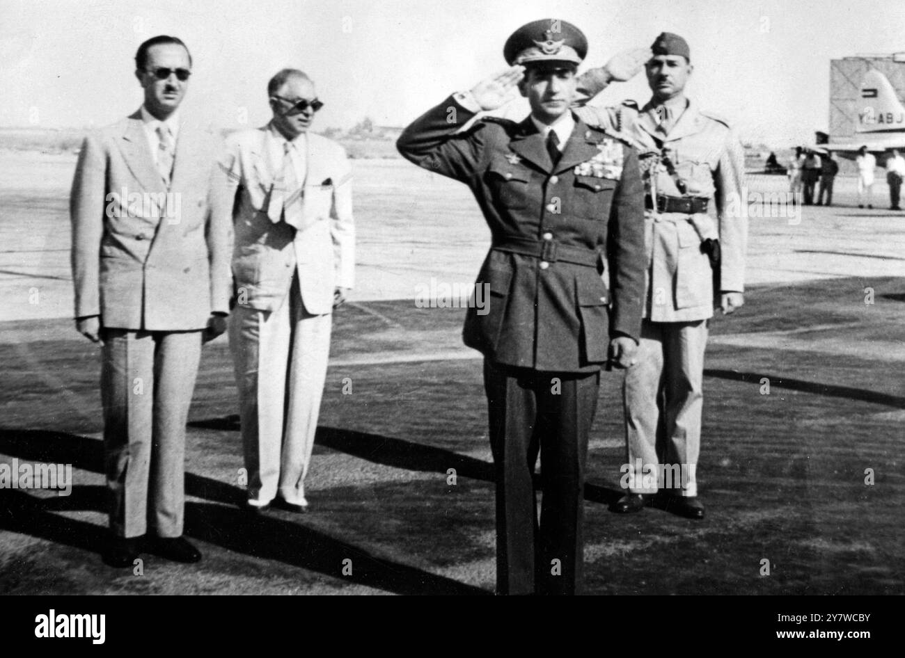 Der Schah verlässt Bagdad nach Teheran 24. August 1953 Bagdad: Der Schah von Persien trägt die Uniform des Air Marshals und grüßt, während die Nationalhymnen des Iran und des Irak vor seiner Abreise nach Teheran am Flughafen Bagdad gespielt werden. Von links nach rechts sind: Kronprinz Abdul Ilah von Irak, Verteidigungsminister Nuri Pascha El-Said, der Schah und Major Mohammed Letayif, ADC bis Kronprinz Abdul Ilah. Stockfoto