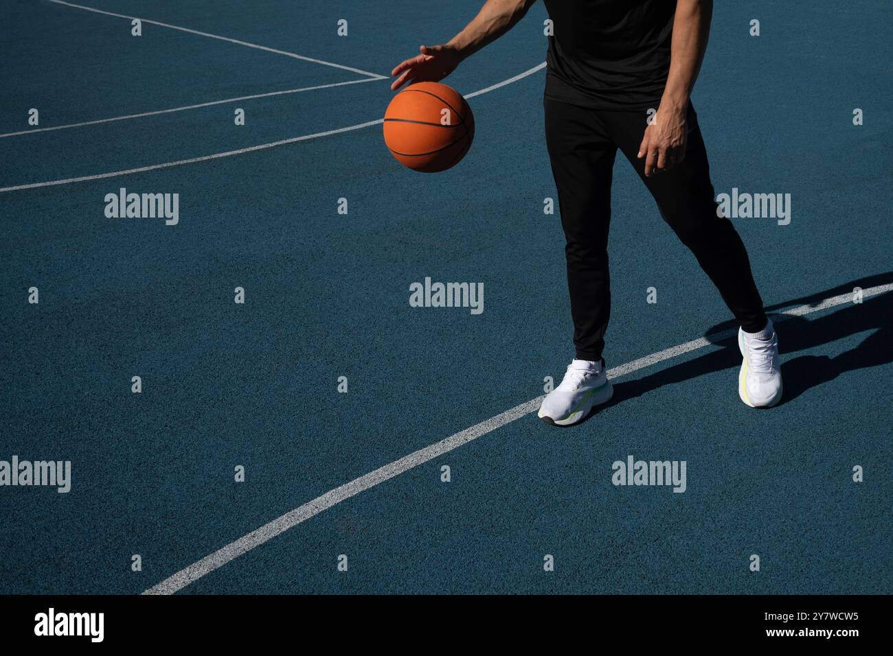 Action-Schuss eines kaukasiers, der draußen auf einem Basketballplatz im Freien Basketball spielt. Kopierbereich Stockfoto