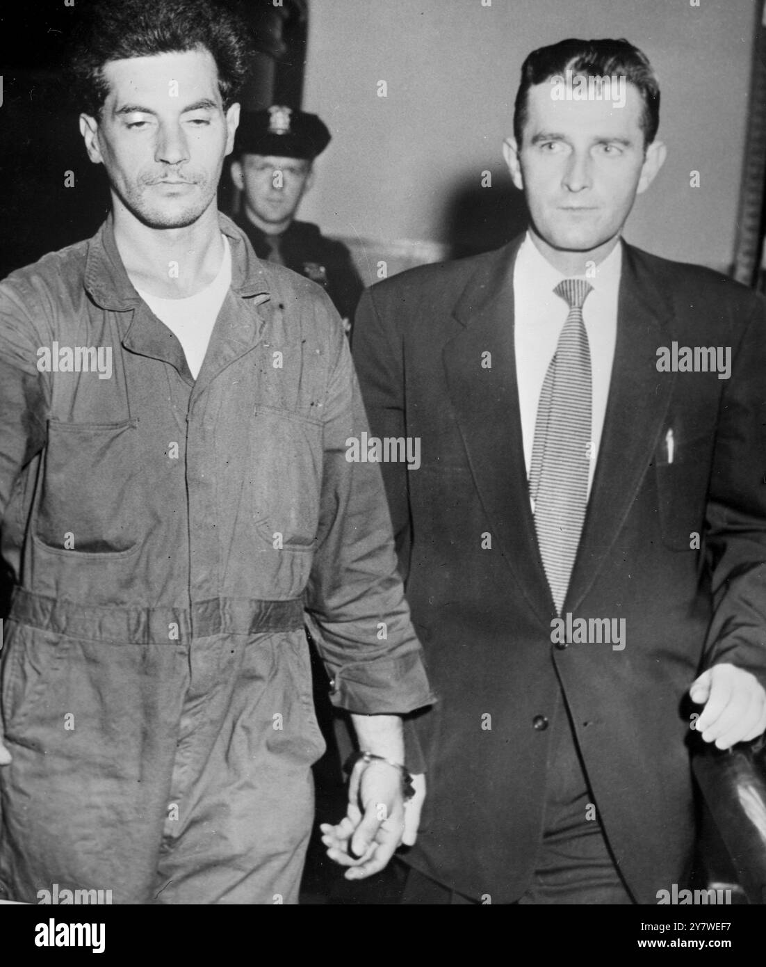 Mineola , New York : Angelo J . LaMarca ( links ) ist an einen Detektiv gefesselt und wird im Polizeipräsidium Nassau gesehen , wo er die Entführung des einmonatigen Peter Weinberger gestand . 26. August 1956 Stockfoto