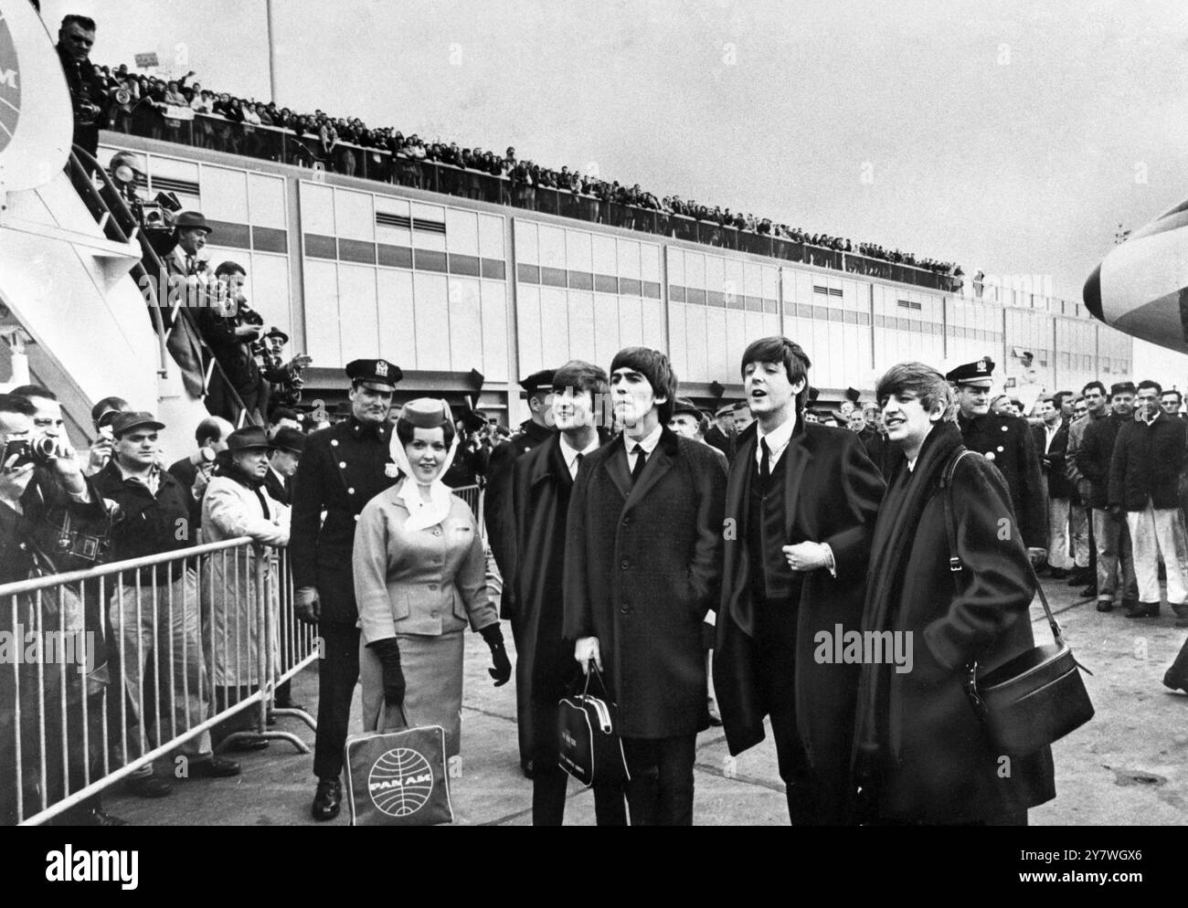Die Beatles von links nach rechts - John Lennon, George Harrison, Paul McCartney und Ringo Starr - treffen auf begeisterte Fans, wie sie bei ihrer Ankunft am 7. Februar 1964 im John F Kennedy International Airport in New York gezeigt werden Stockfoto