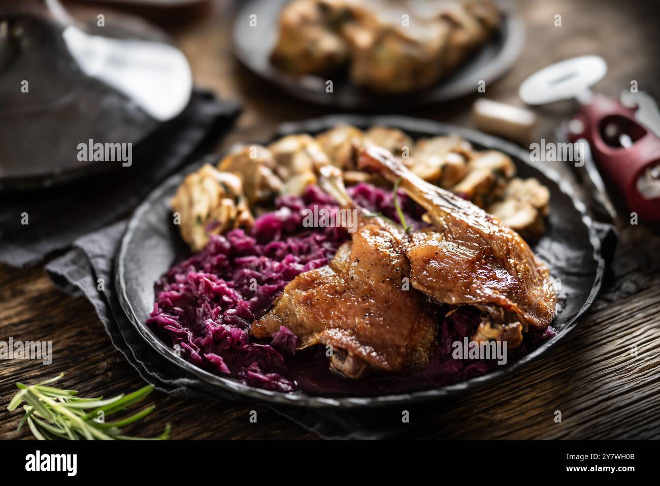 Teil der Gebratene Entenkeule, Rotkohl hausgemachte Knödel auf dem Teller und Rotwein auf dem Hintergrund. Stockfoto