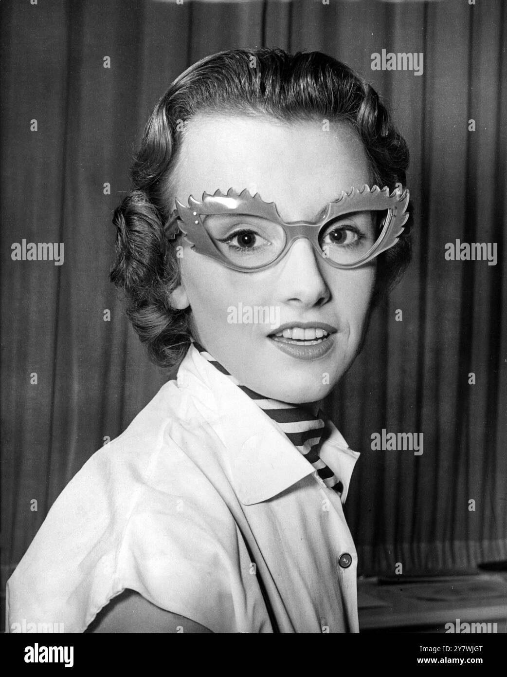 Diese magentafarbene Brille wurde von Bettie Spurling für Dixey's, die berühmten Londoner Optiker, entworfen. Besonders auffällig sieht Jenefer Randolph 7. Januar 1954 aus Stockfoto