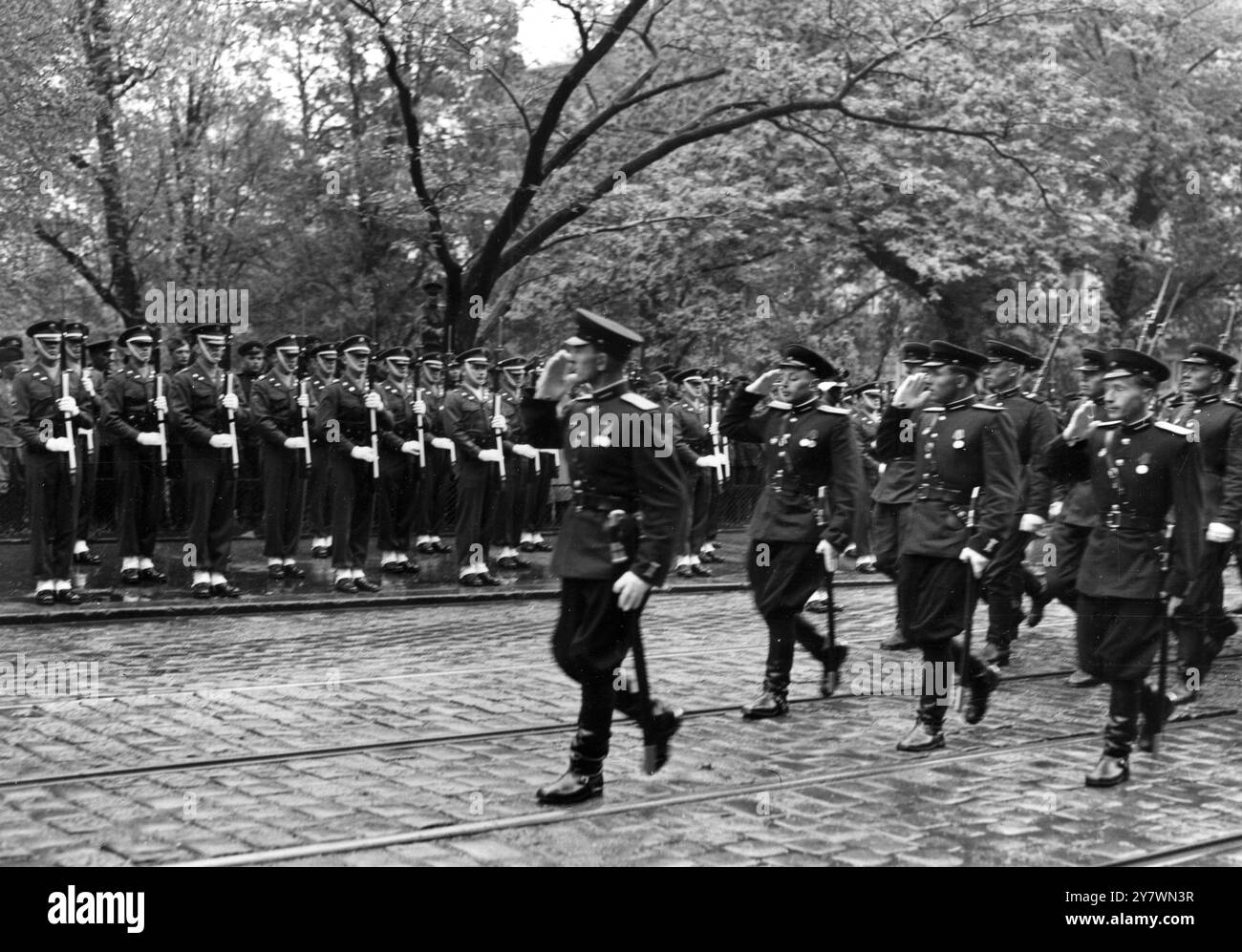 Eine Kompanie sowjetischer Soldaten gibt den Gruß amerikanischer Soldaten zurück, während sie während des farbenfrohen monatlichen Wechsels der Internationalen Zonenwache im Blick behalten. Die Internationale Zone Wiens wird monatlich gewechselt. Die Russen übergaben den Amerikanern für Maiaufgaben . Die Briten übernehmen im Juni , und Franzosen und Russen folgen . 3. Mai 1951 Stockfoto